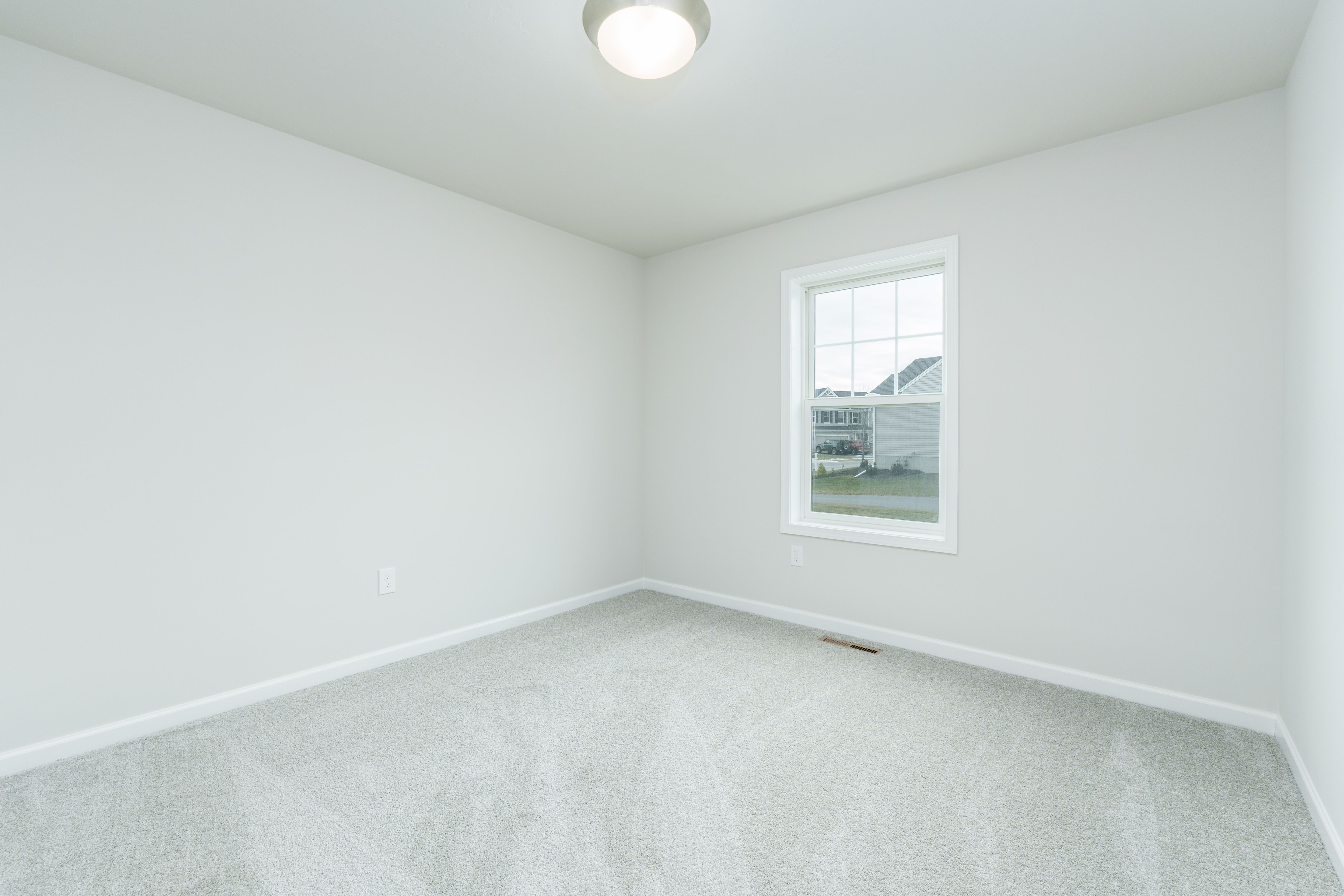 Bedroom with carpeted floor, light-colored walls, single window, and ceiling-mounted light fixture