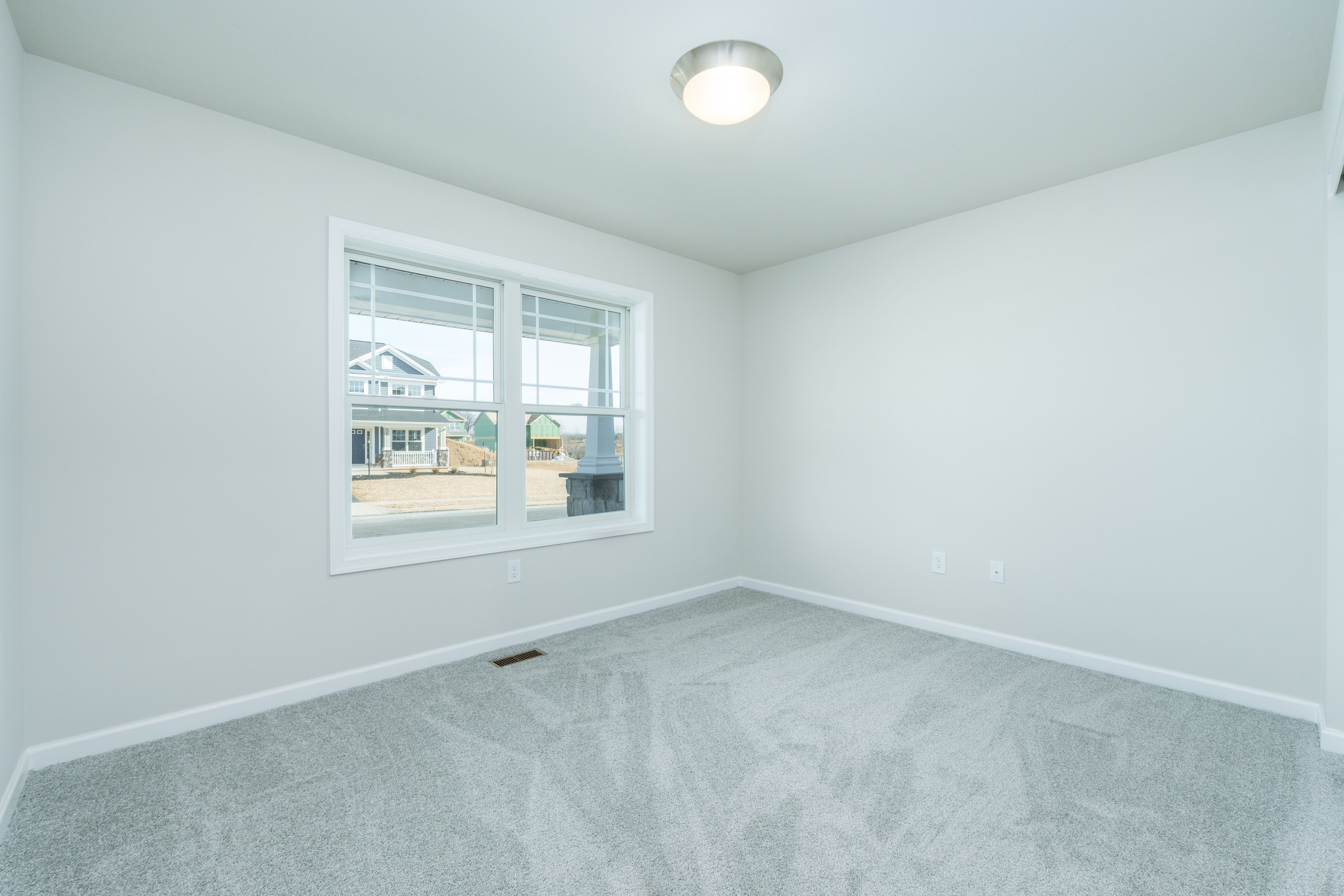 Bedroom with neutral carpet, large window, and bright natural light
