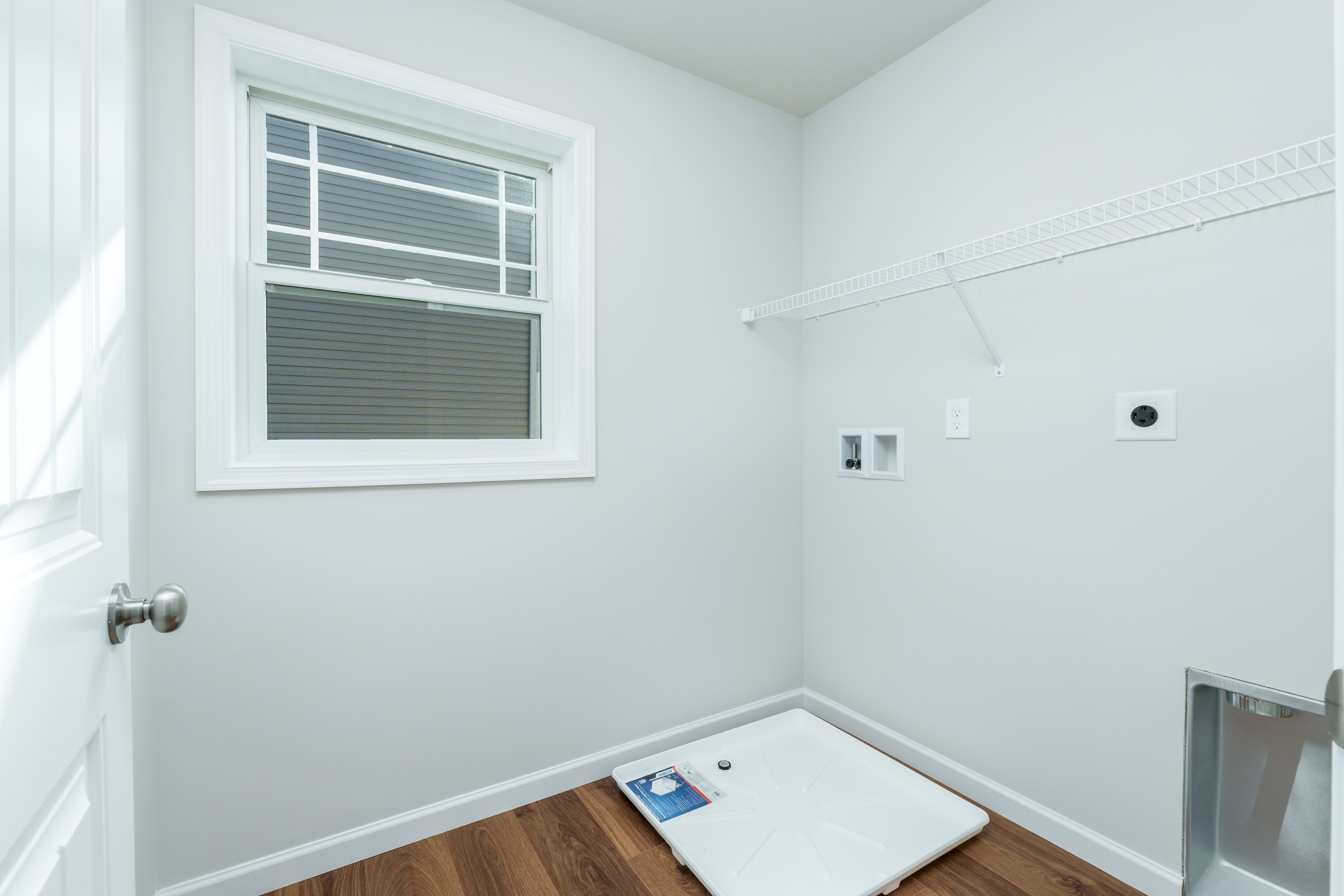 Laundry room with window, wire shelf, washer hookups, and luxury vinyl plank flooring