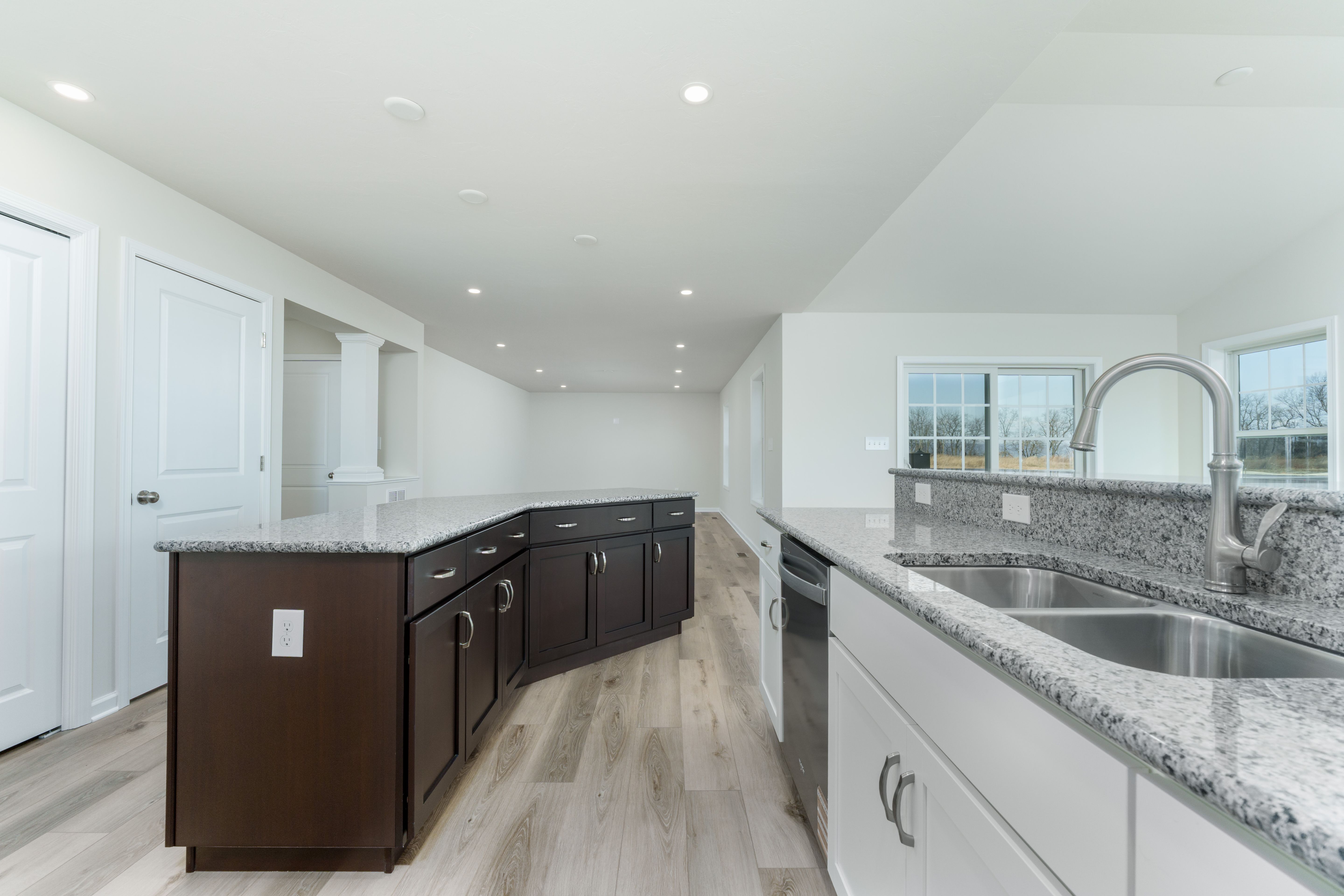 Kitchen with granite island, stainless steel dishwasher, white cabinets, and open layout to morning room.