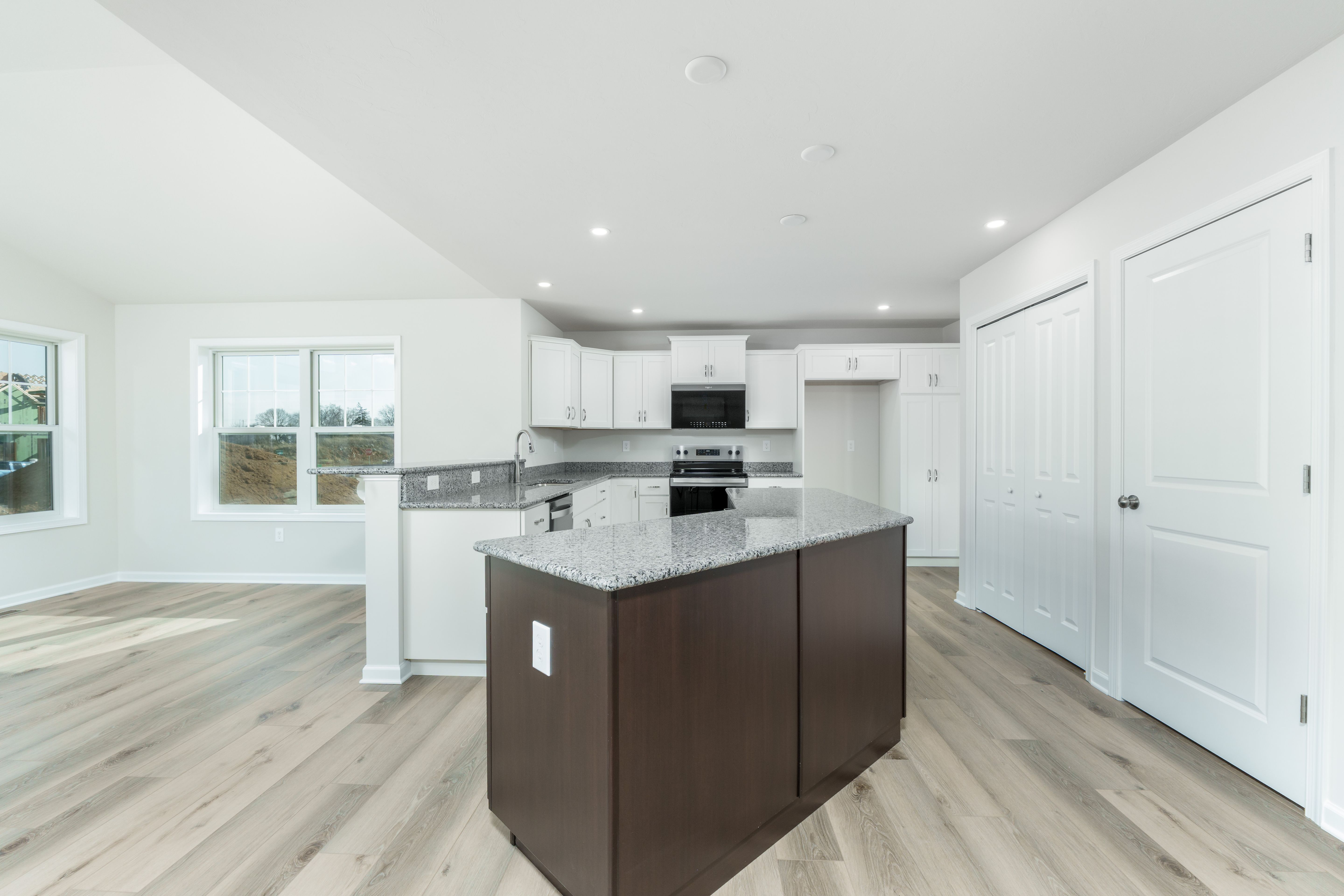Spacious kitchen featuring large island, granite countertops, recessed lighting, and open sightline to morning room.
