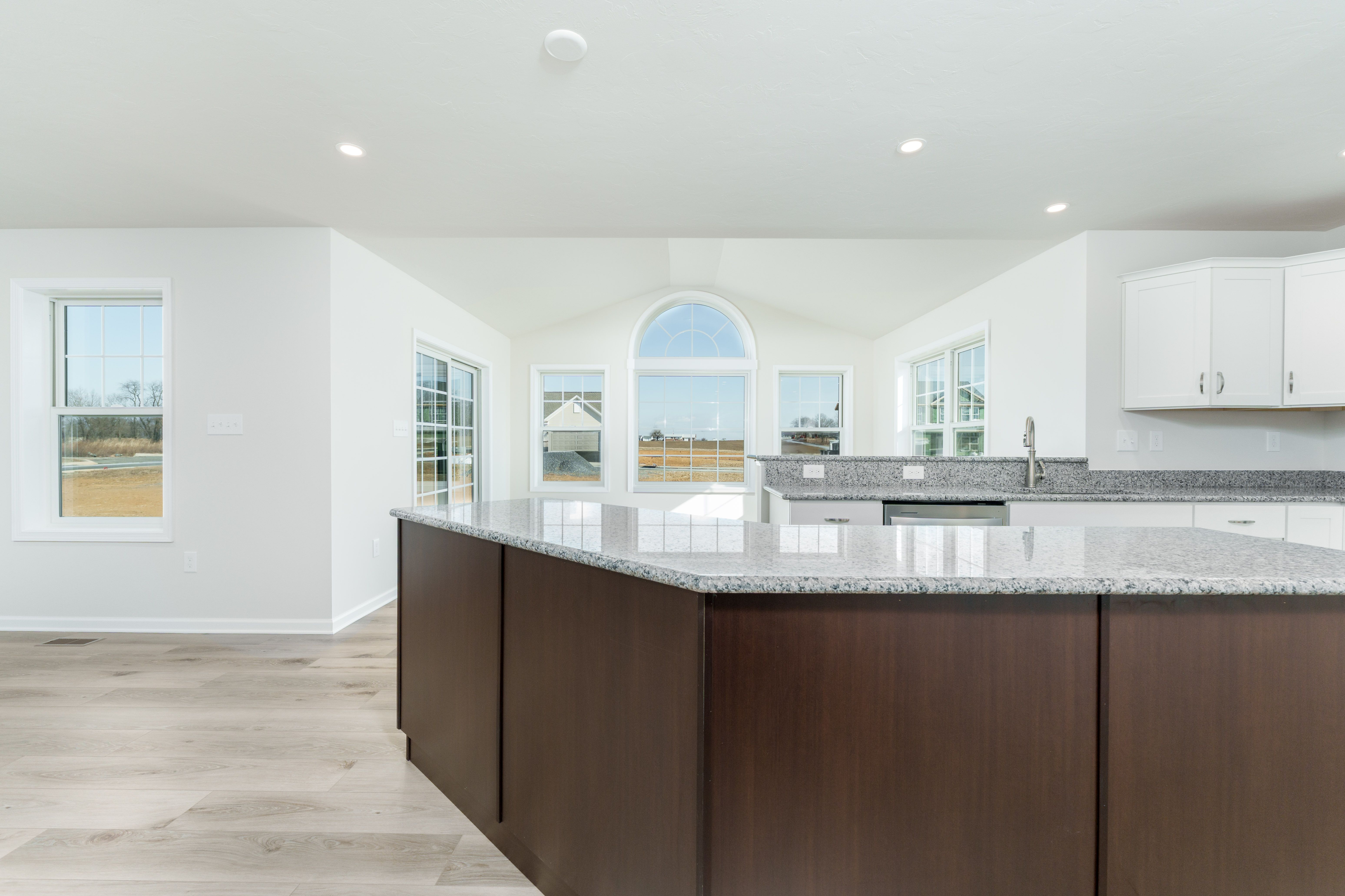 Kitchen with raised breakfast bar, granite countertops, white cabinetry, and adjacent morning room.