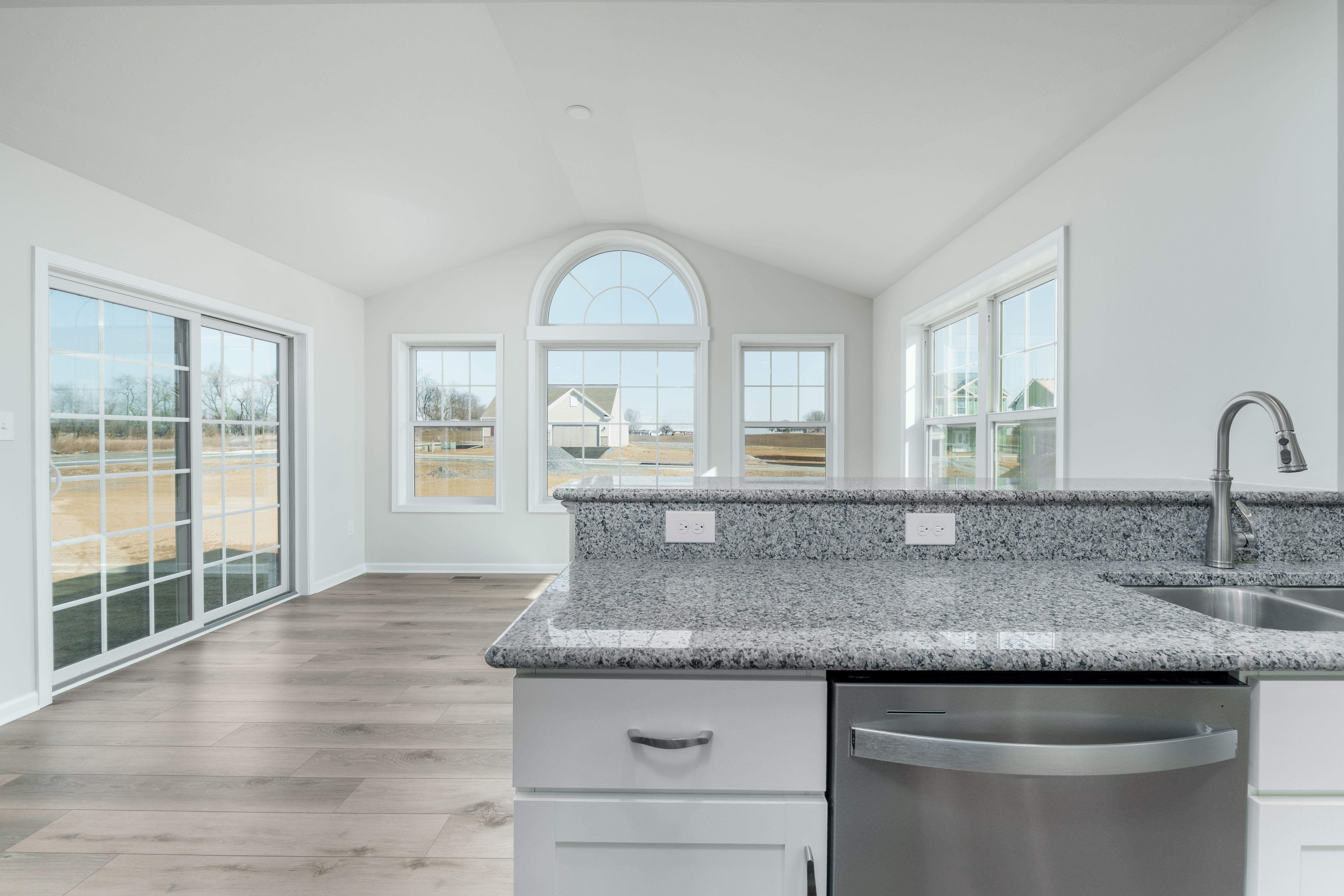 Morning room with large arched window, sliding glass door, and luxury vinyl plank flooring.