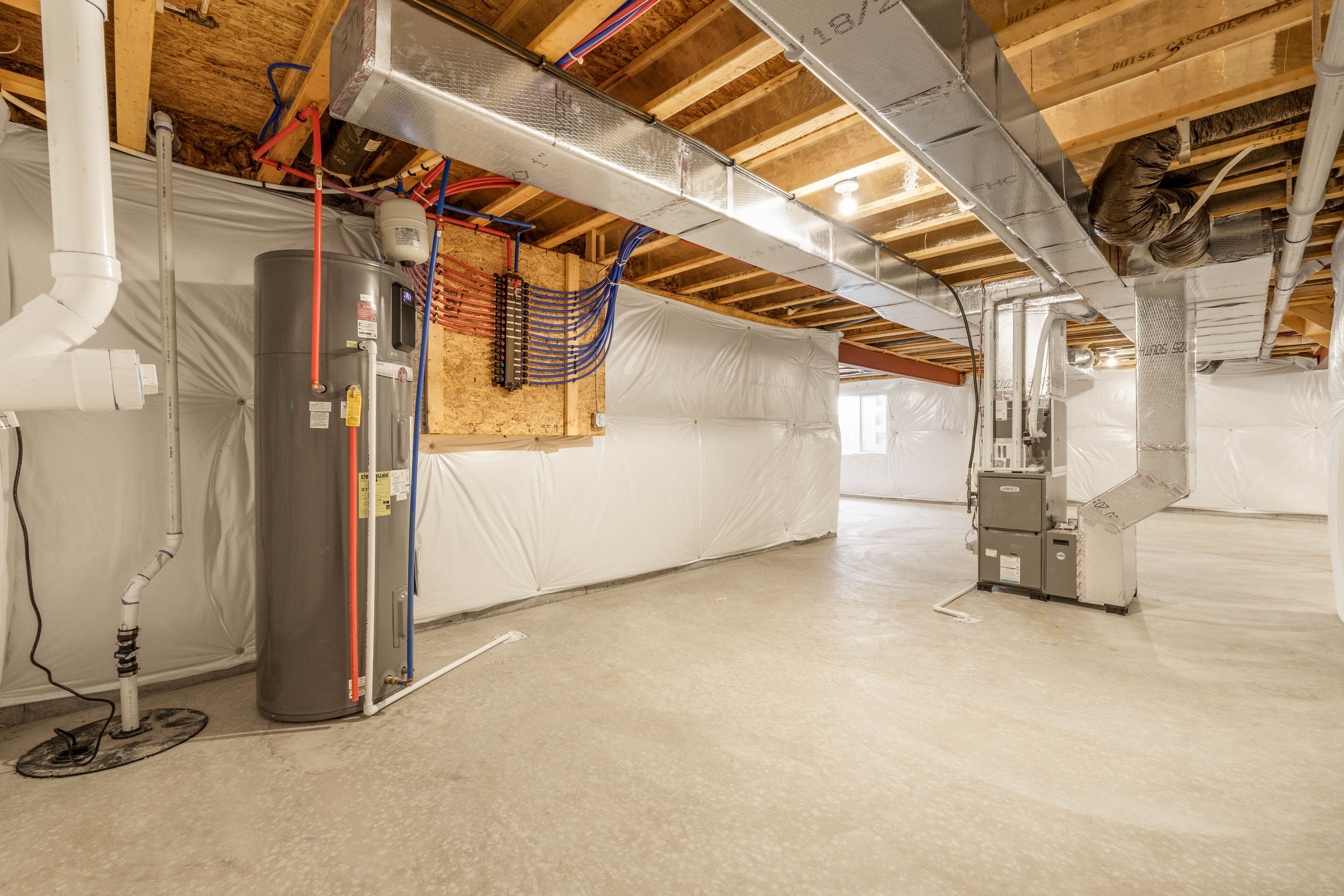 Basement utility area with water heater, HVAC system, exposed ductwork, and insulated walls over concrete floors.