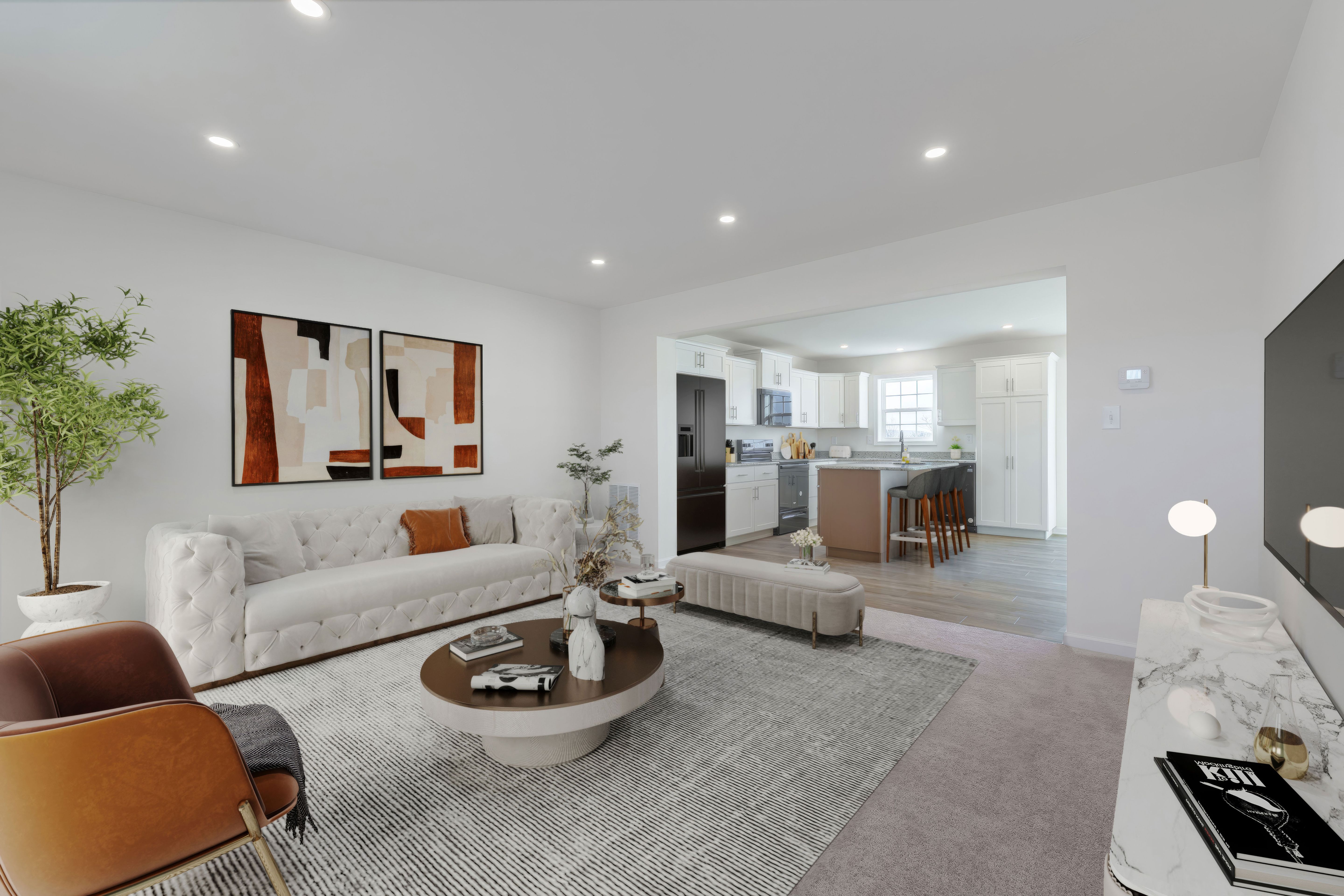 Spacious family room with sofa, accent chair, and open view into bright kitchen