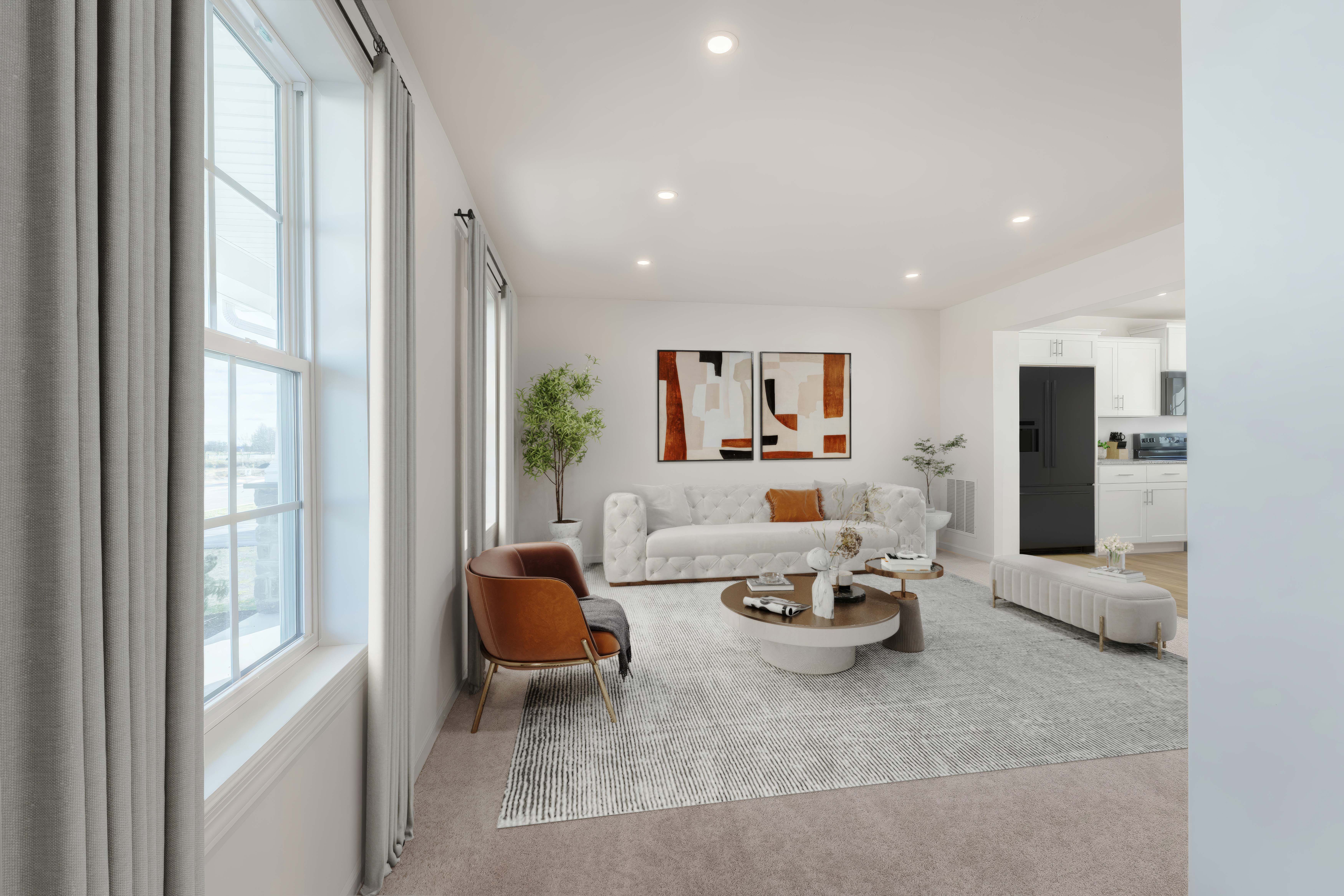 Family room with large windows, modern sofa, and cozy seating area with neutral decor