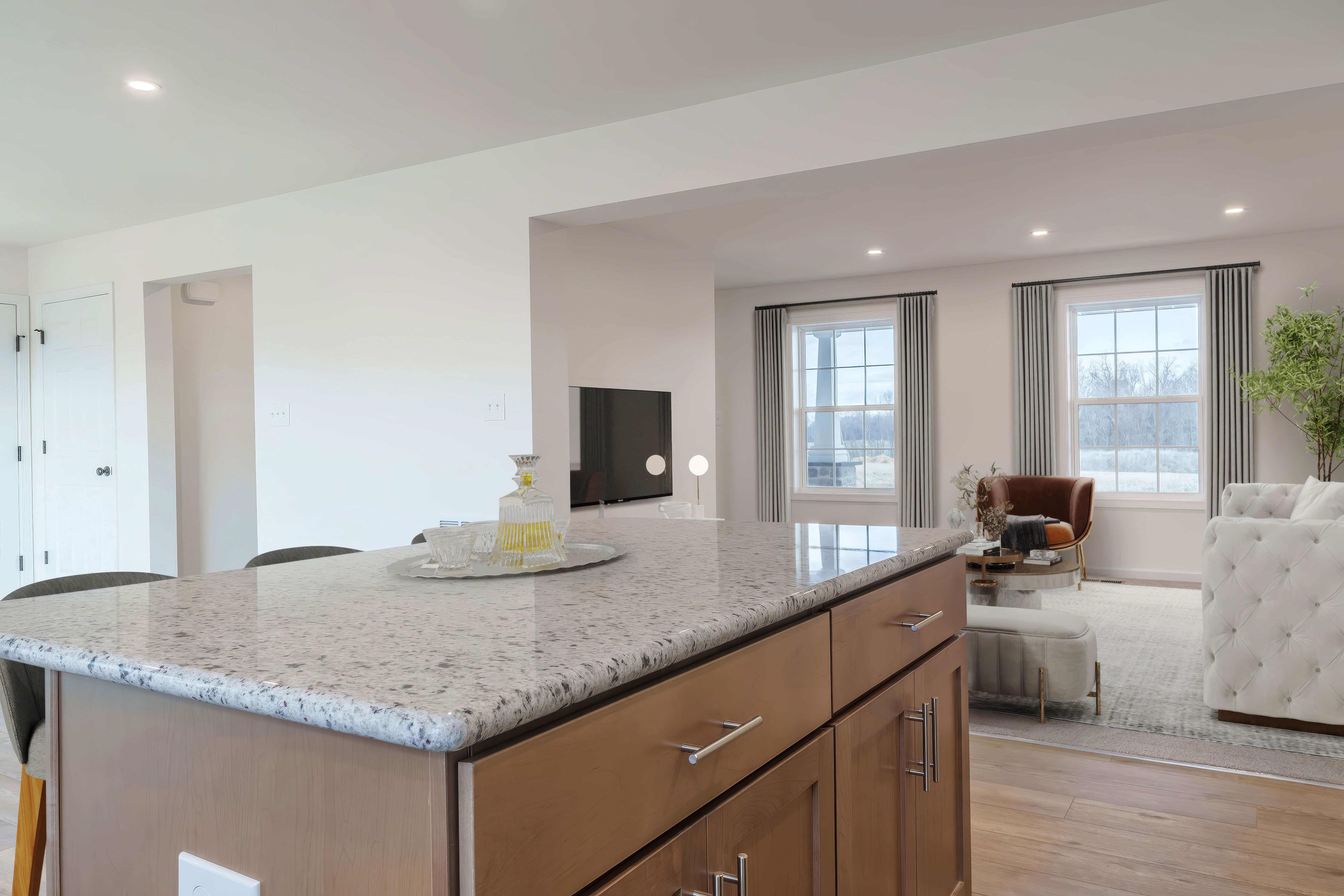 Kitchen island overlooking family room with large windows and cozy seating area
