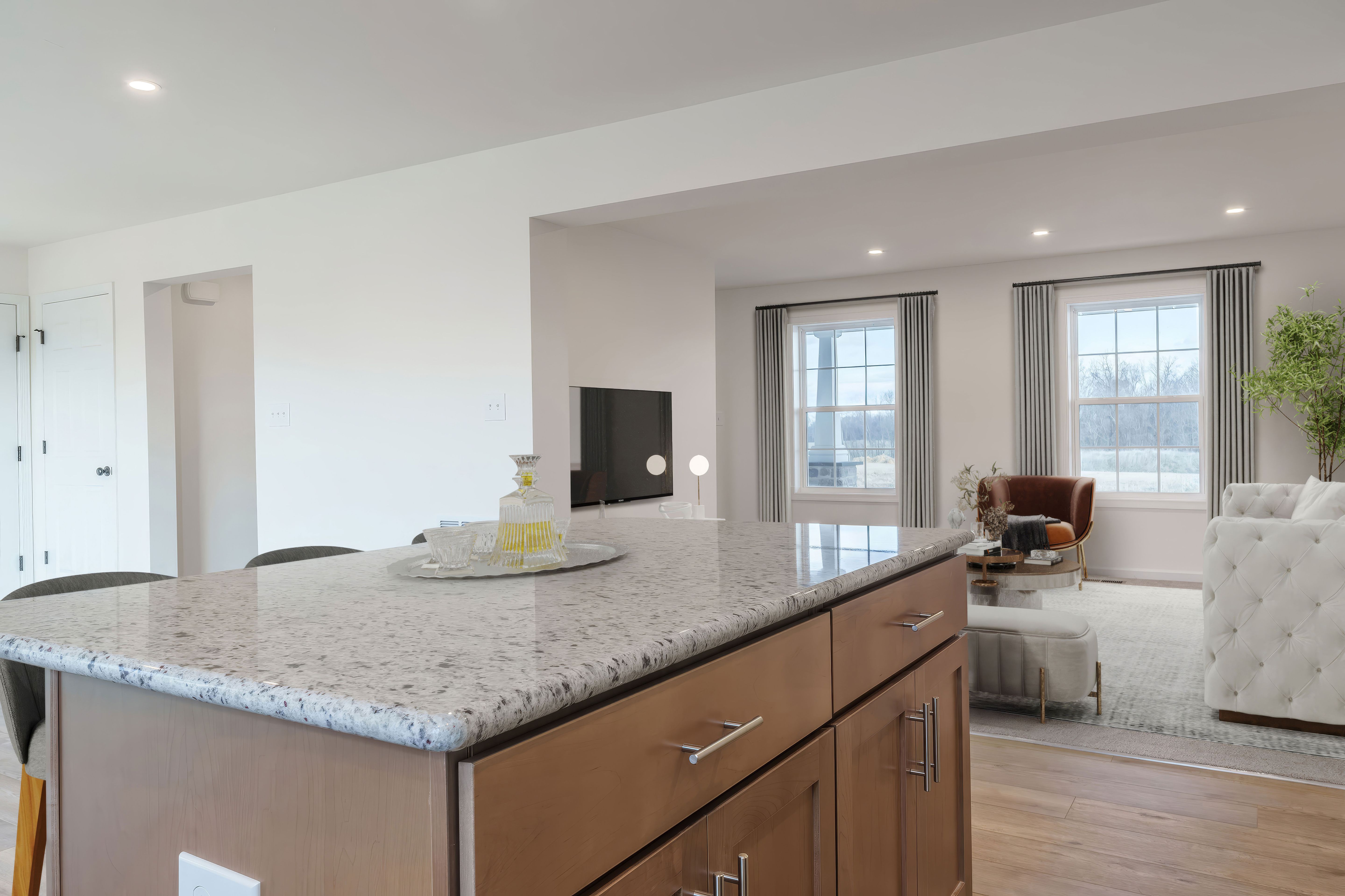 Kitchen island overlooking family room with large windows and cozy seating area