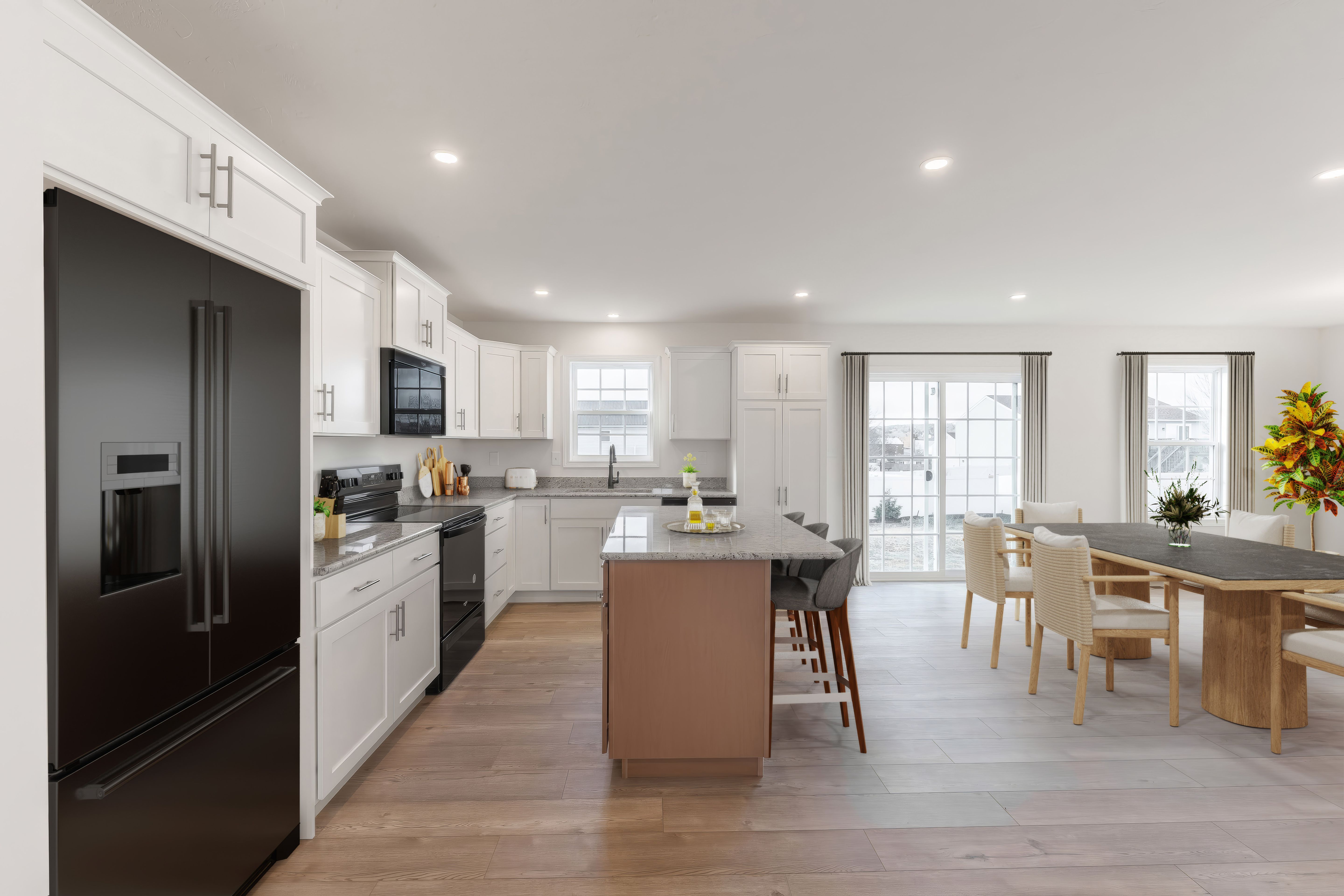 Open kitchen and breakfast area with island seating, large windows, and luxury vinyl plank flooring