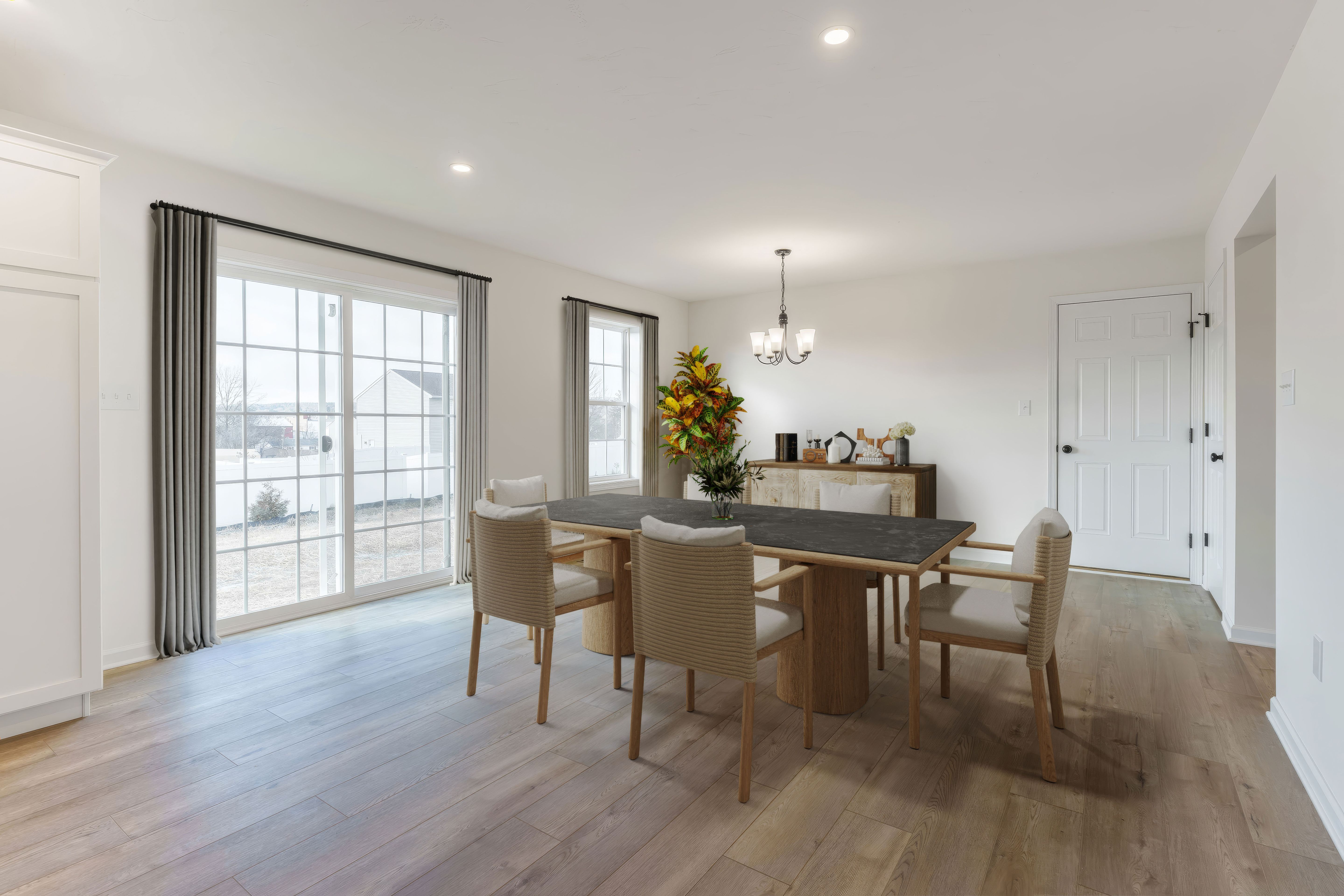 Breakfast area with table for four, large sliding glass doors, and luxury vinyl plank flooring