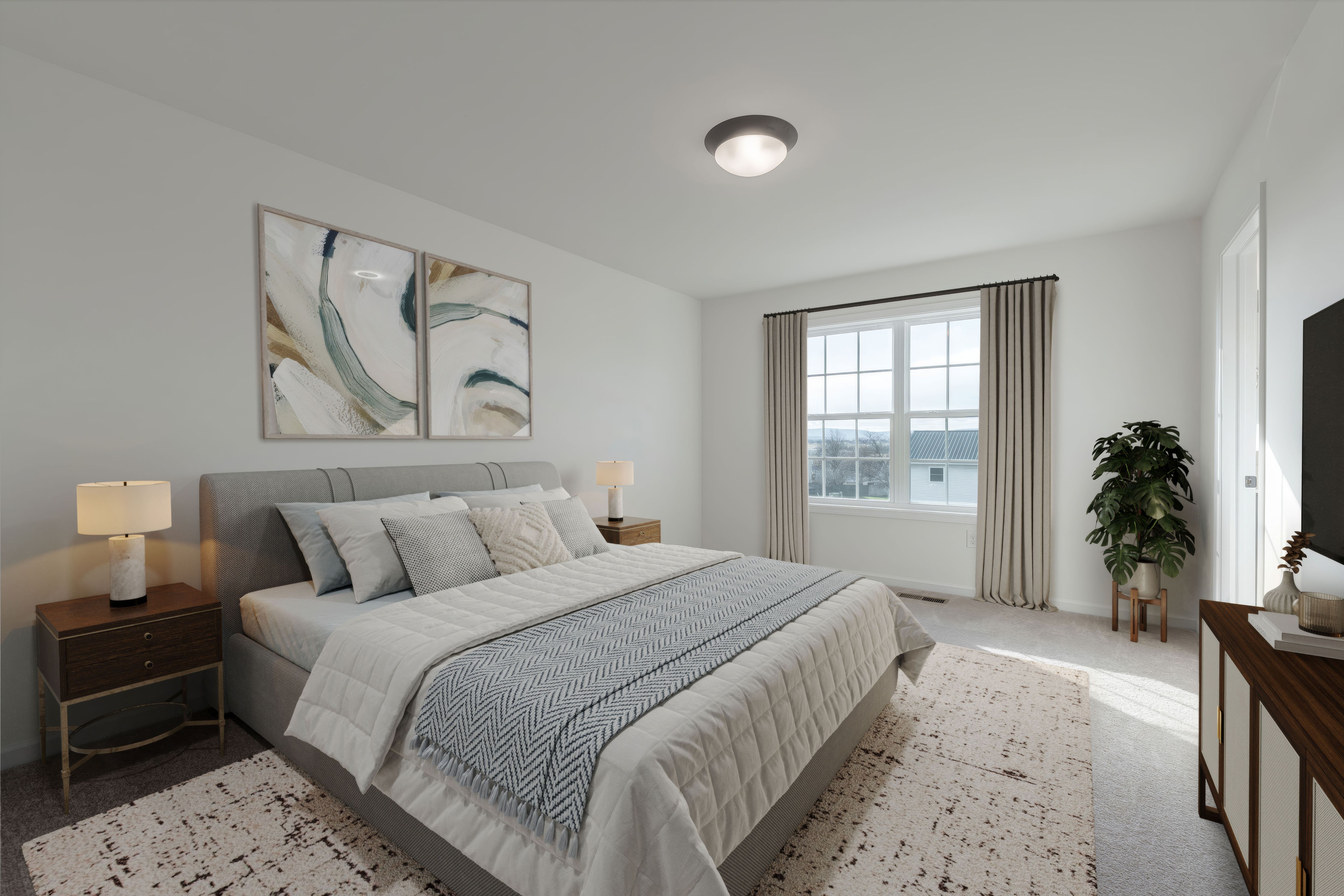 Spacious owners bedroom with upholstered bed, dual nightstands, and large window
