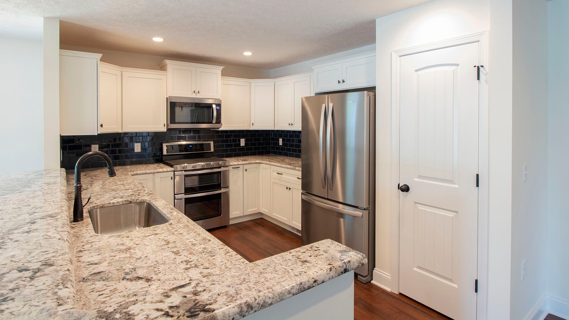 Kitchen with granite countertops, stainless appliances and upgraded cabinetry in Aspen plan by S&A Homes