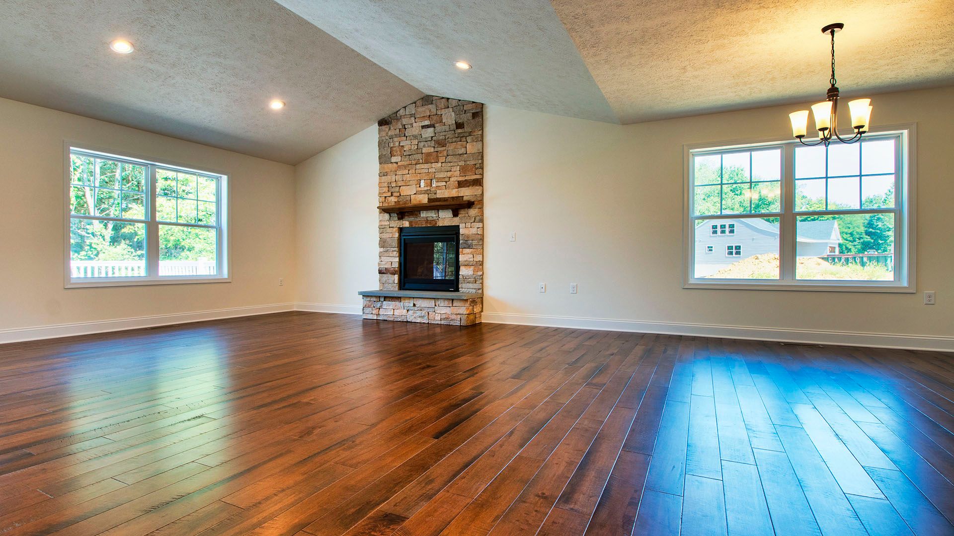 Family room with hardwood floors and fireplace with stone surround