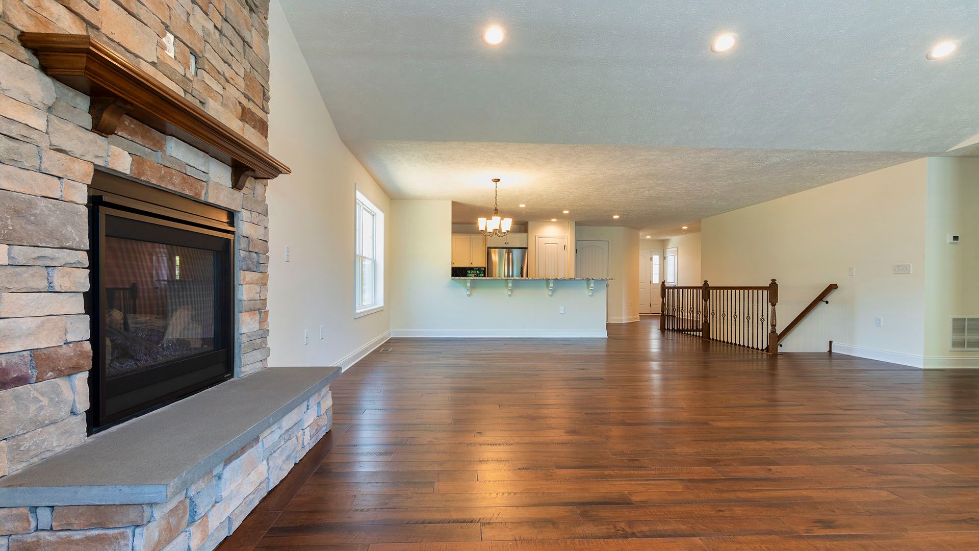 View into family room with hardwood flooring, stone fireplace, Aspen floorplan