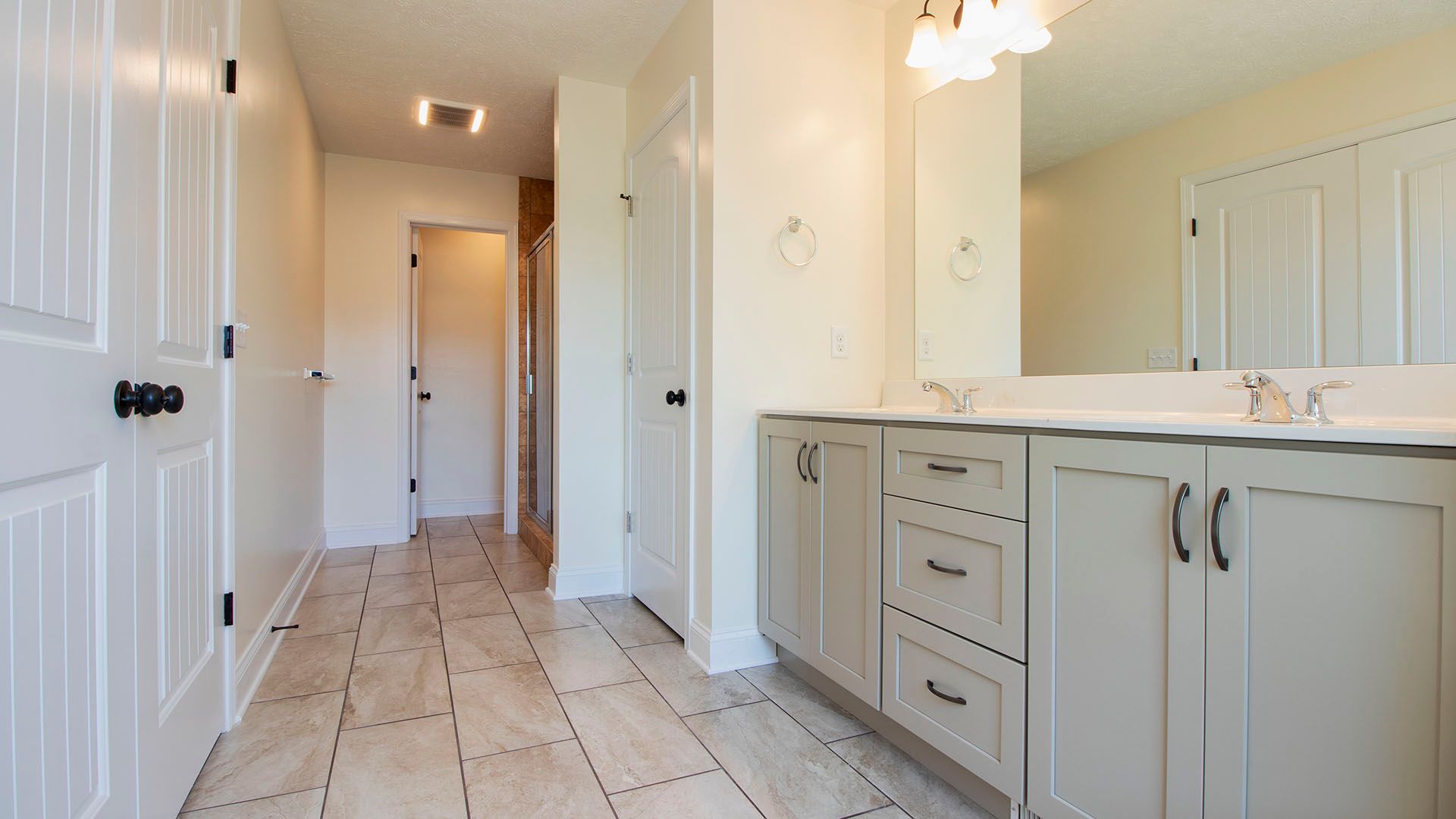 Luxury owners bath with double bowl sink and ceramic tile floor in the Aspen floorplan