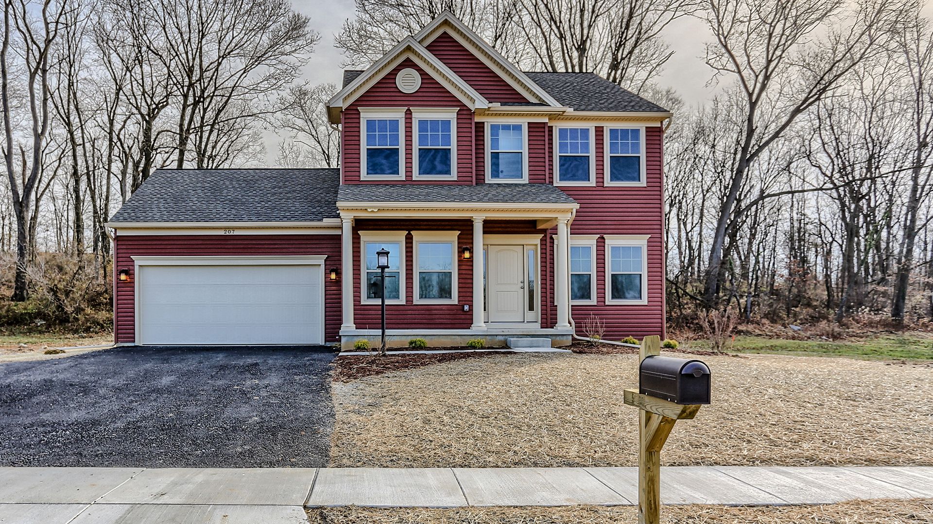 Front exterior view of the Fairmont floorplan by S&A Homes - two story home with covered front porch, double gable on roof, and two car attached garage