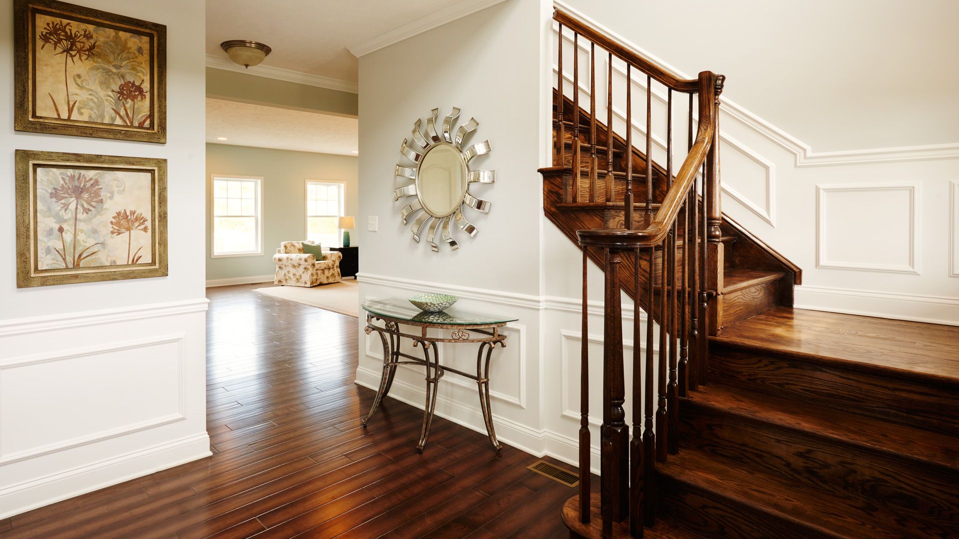 Entry foyer with hardwood flooring and turned oak staircase