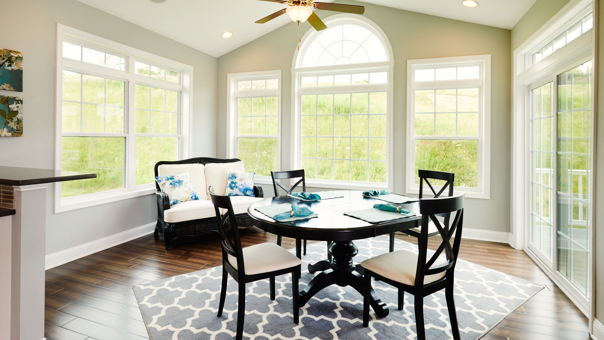 Morning room with large windows, vaulted ceiling, and hardwood floor