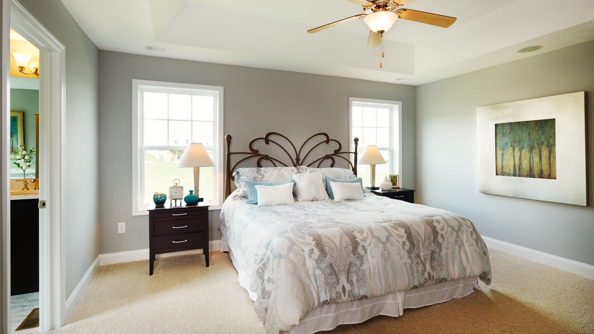 Furnished owner's bedroom with large windows, and carpeted floor