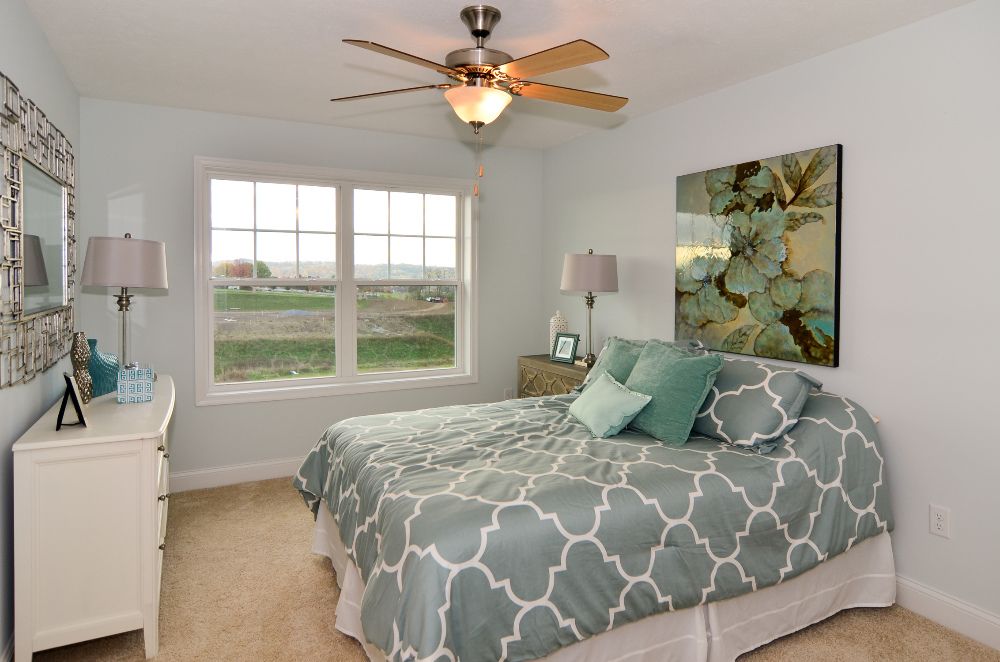 Furnished guest room with double windows on rear wall, and carpeted flooring