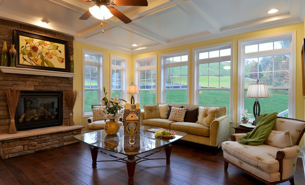 Family room with gas fireplace with stone surround and wall of windows