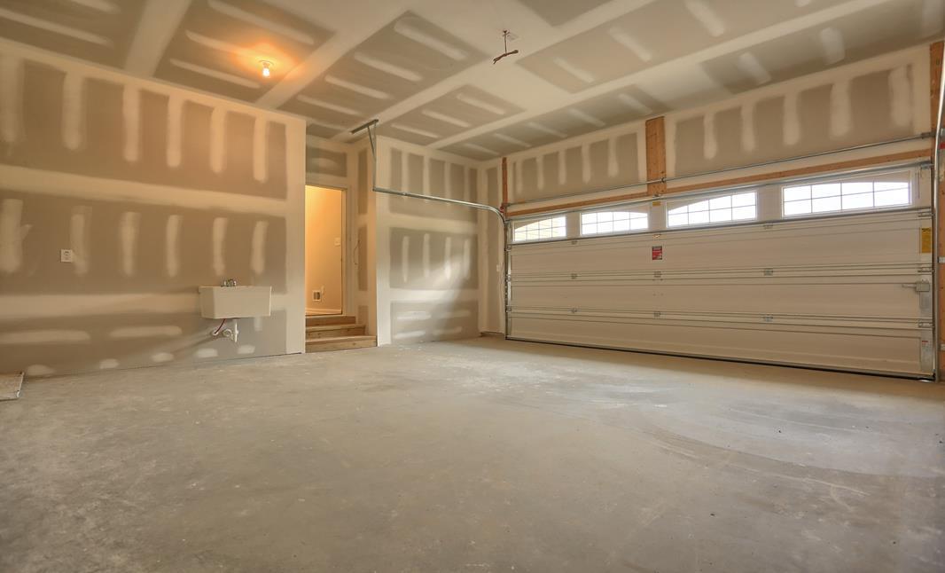Two car garage with unfinished walls and ceiling