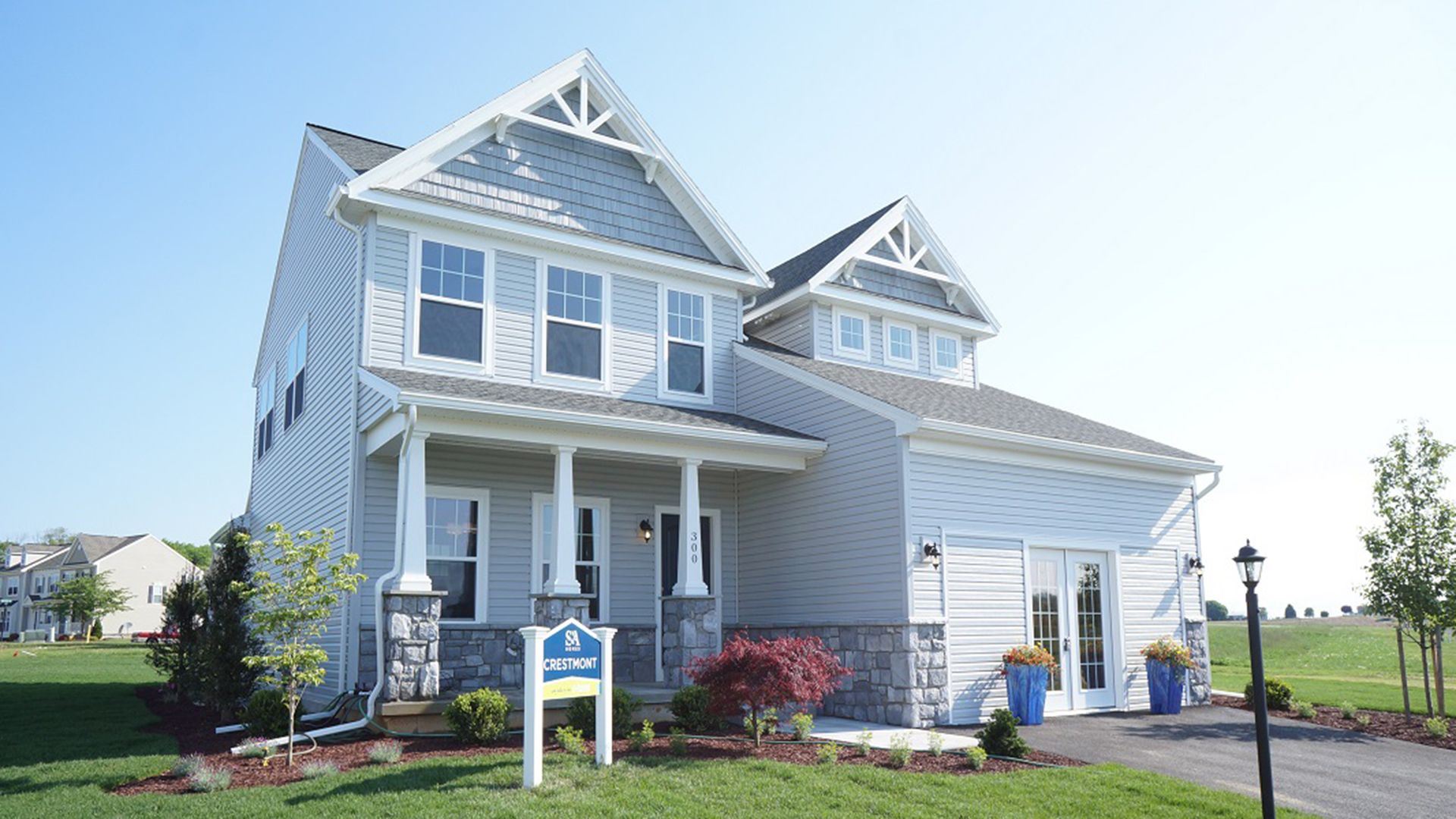 The Crestmont C by S&A Homes - decorated model home at Deerfield in Shippensburg - two story Craftsman style home with vinyl siding, partial stone, front porch, and two car garage with dormer above