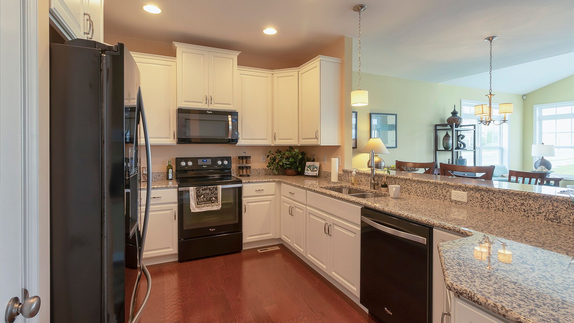 Kitchen with white cabinets, black appliances and granite countertops, Crestmont floorplan by S&A Homes