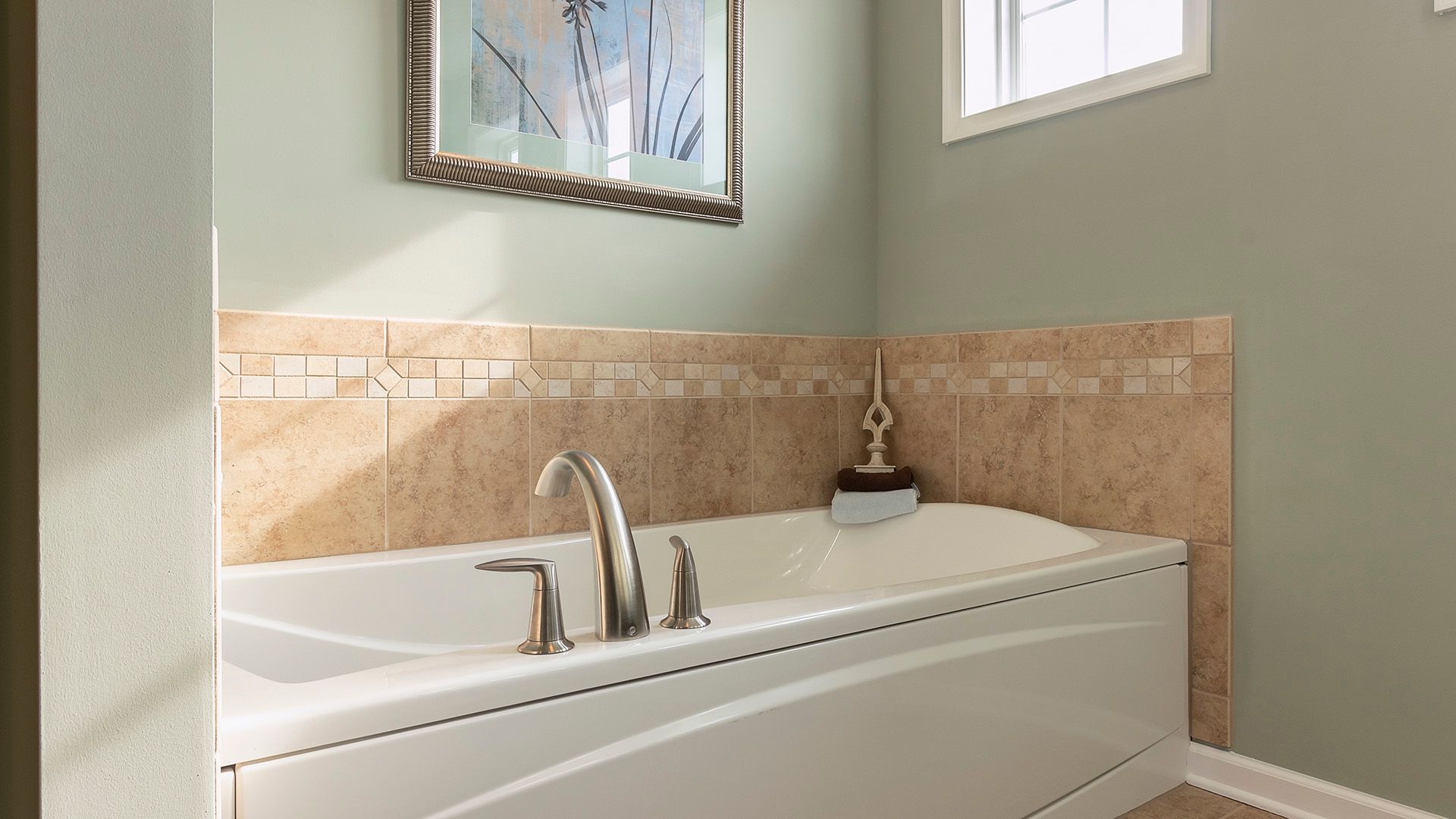Soaking tub with ceramic tile surround in Crestmont floorplan by S&A Homes