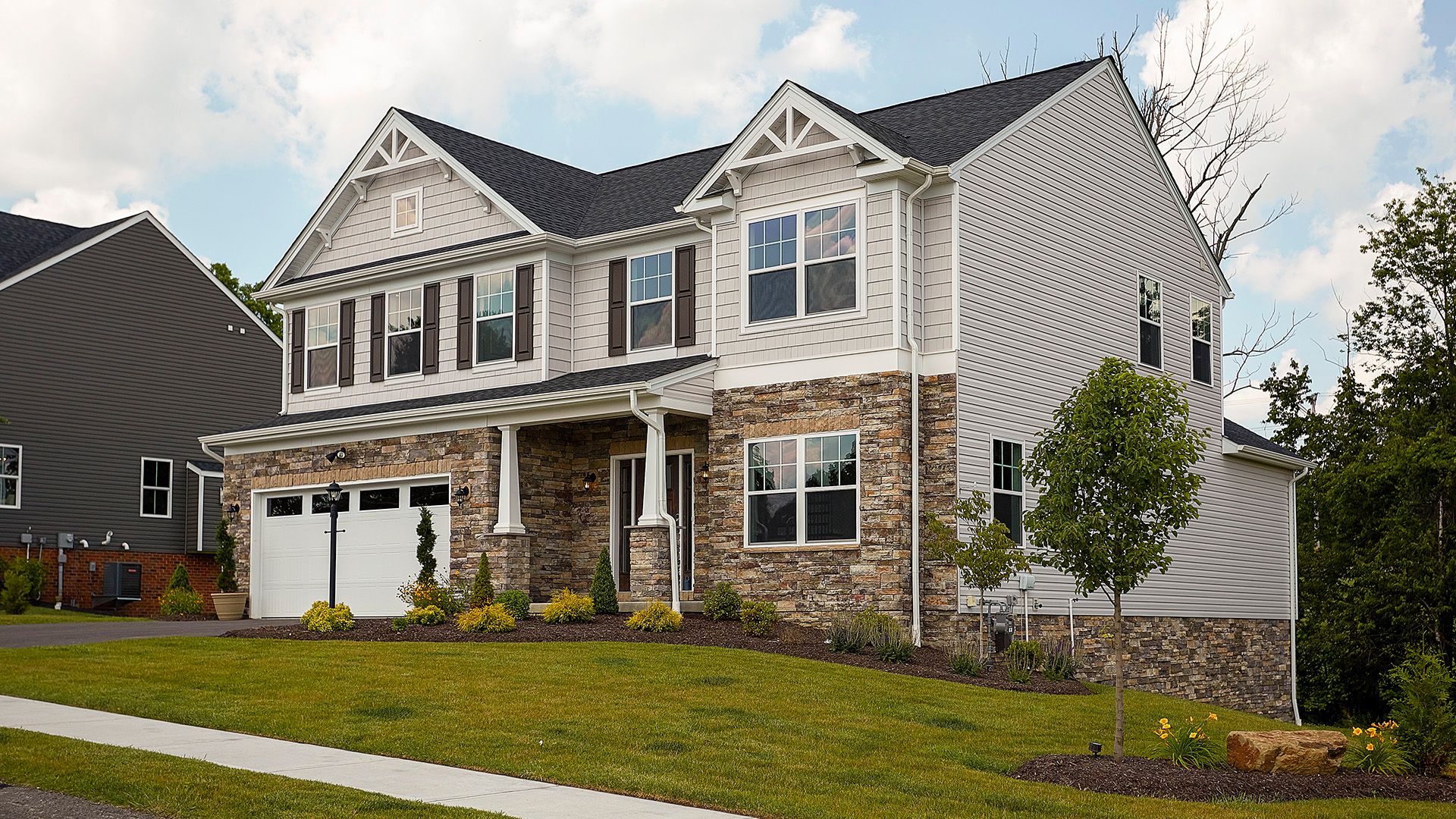 Exterior front view of the S&A Homes Dartmouth C plan - 2 story Craftsman style design with covered entry and partial stone front