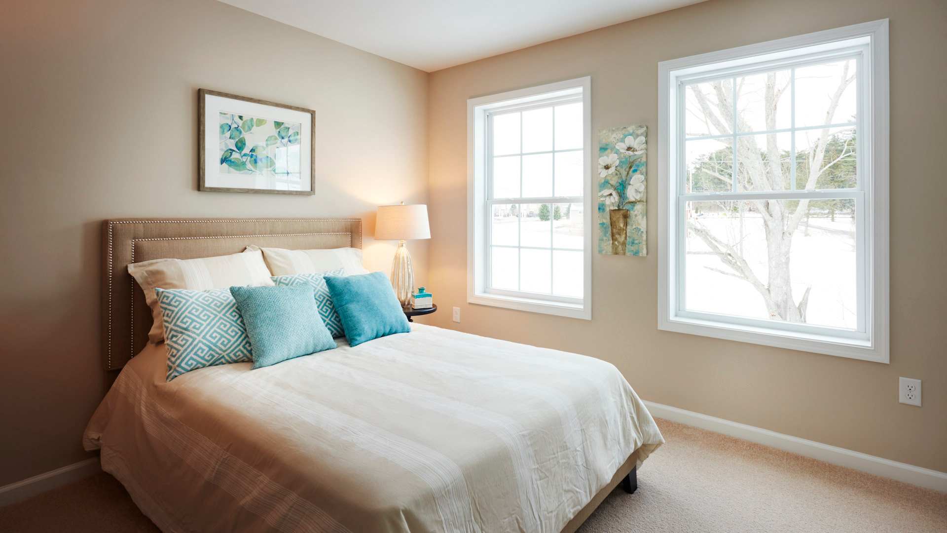 Furnished guest room with double windows on front wall and carpeted floor