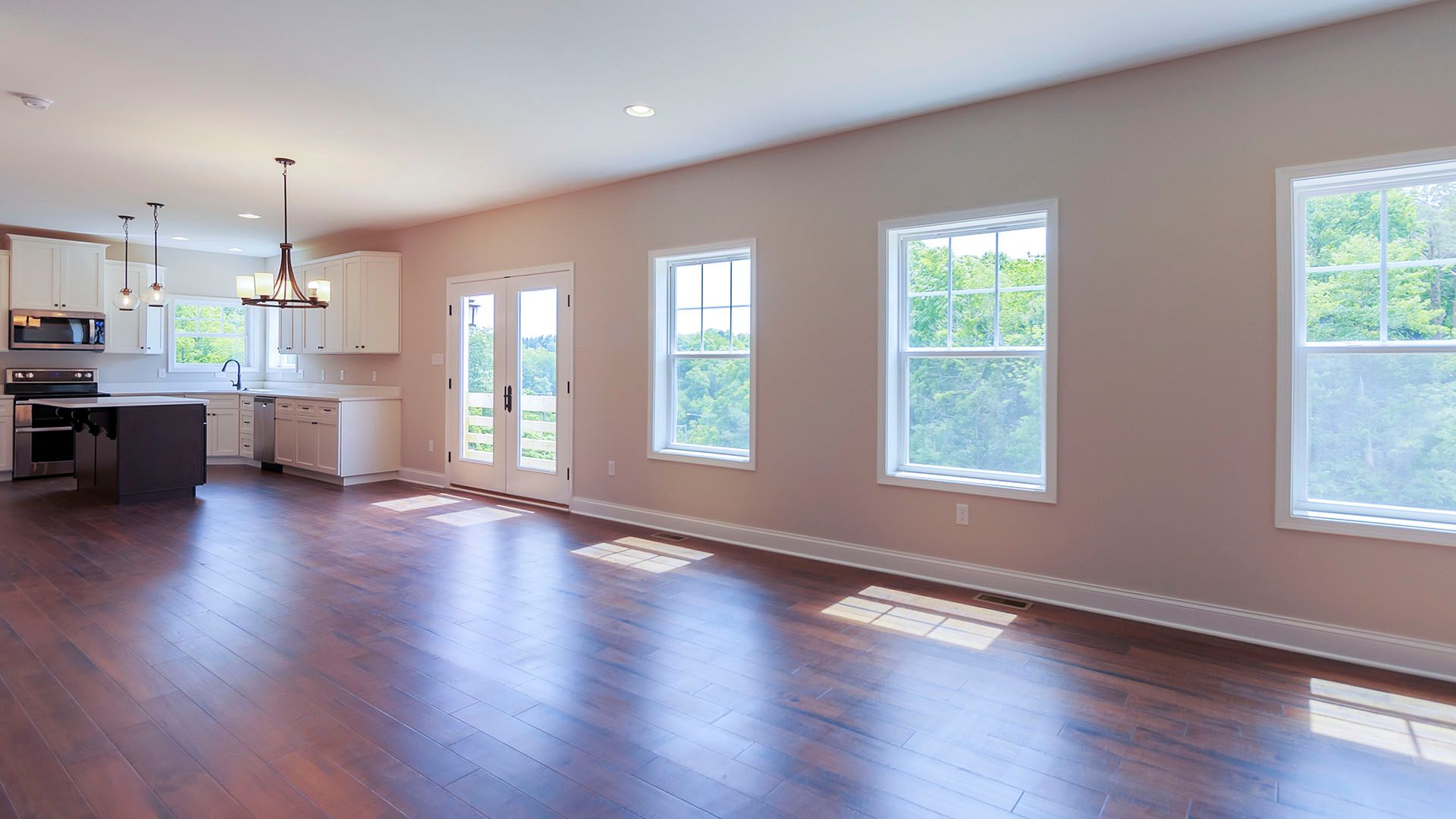 Great room with 3 windows, double glass door, looking into kitchen