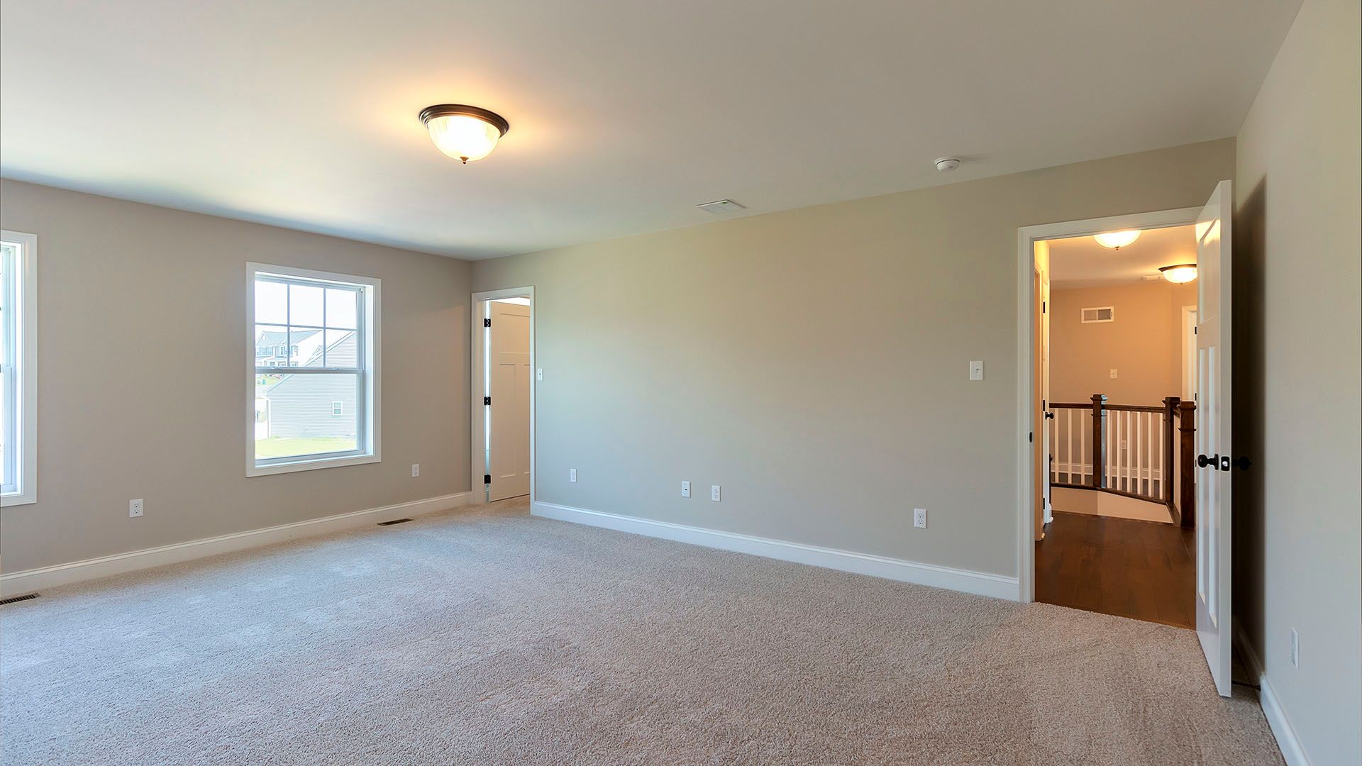 Owner's bedroom with 2 windows, carpet, door leading to hallway