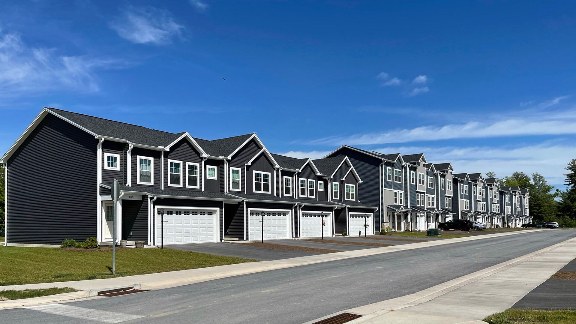 The Woodfield and Bradfield townhomes at Grays Pointe in State College - Streamline Series by S&A Homes- streetscape view - two and three story townhomes with 2 and single car garage - vinyl siding fronts