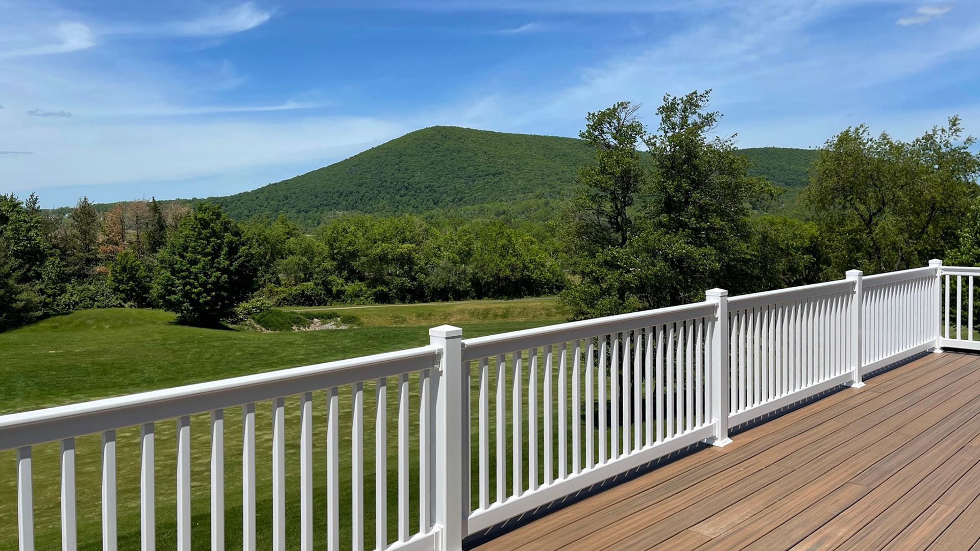 S&A Homes Village at Canterbury in State College - rear deck with white rails, with Mt. Nittany in the background.