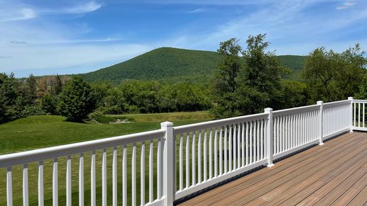 S&A Homes Village at Canterbury in State College - rear deck with white rails, with Mt. Nittany in the background.