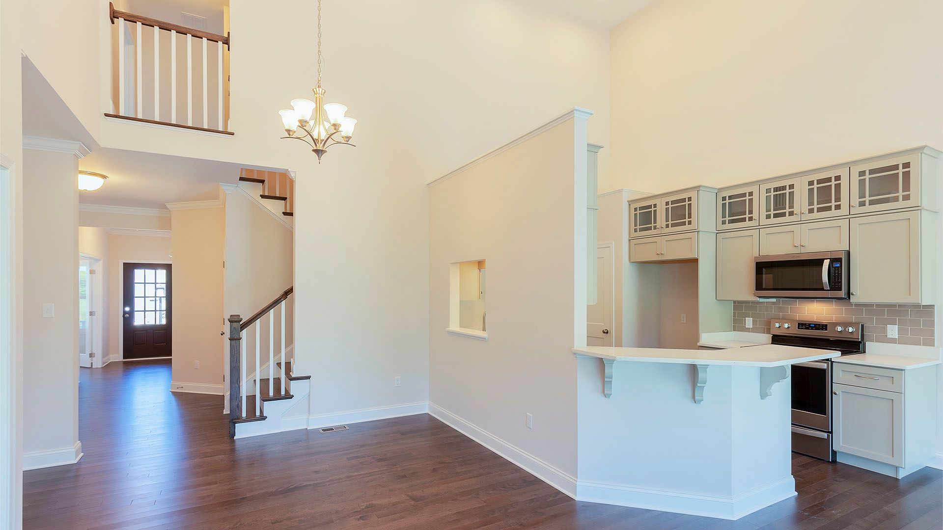 View from family room of vaulted ceiling and 2nd floor loft overlook, kitchen, and front entry foyer, Chilton plan