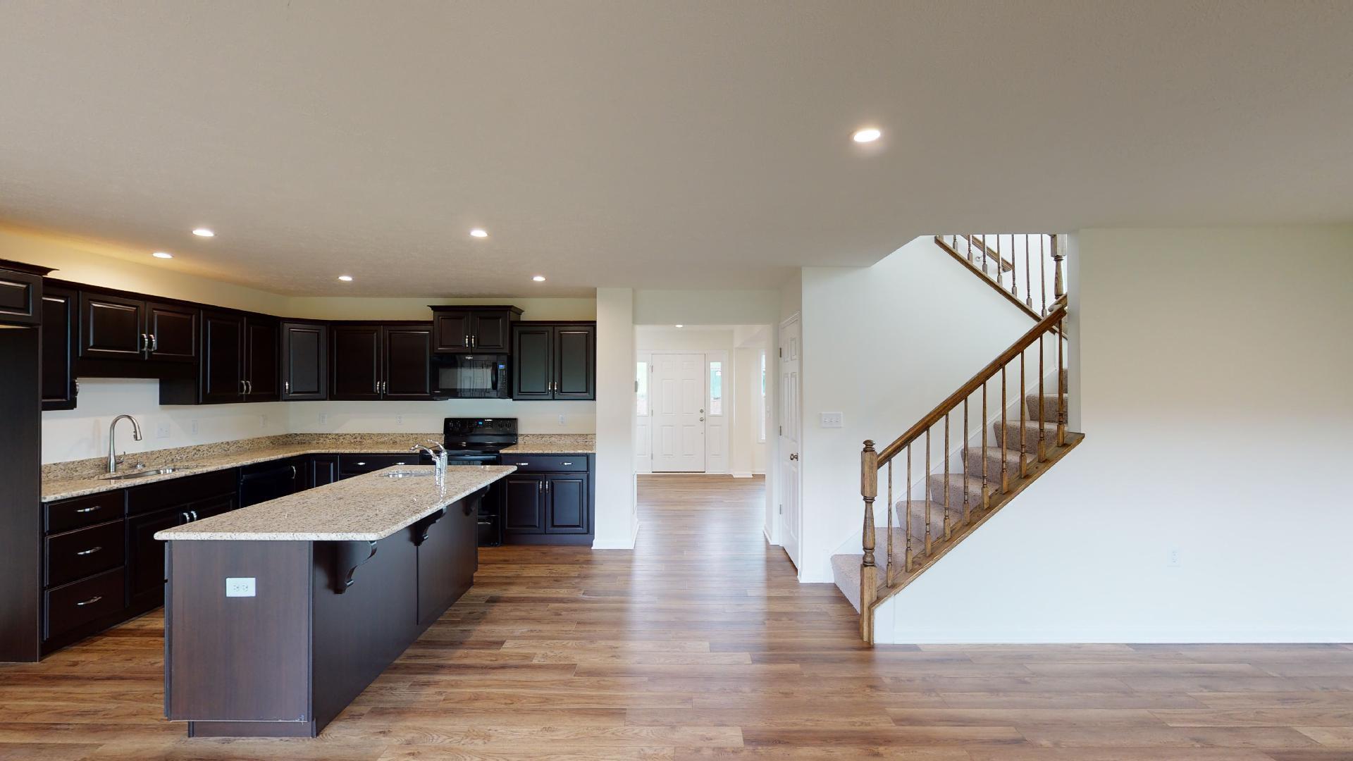 Foyer entry, kitchen, and staircase - vinyl plank flooring throughout
