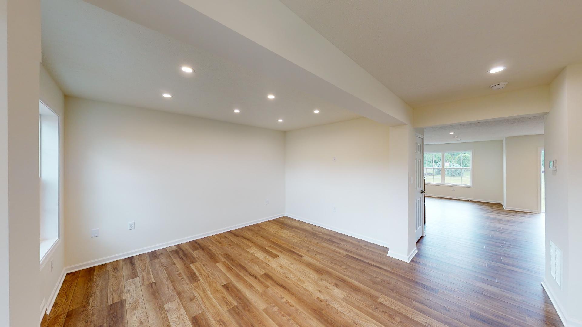 Living room with vinyl plank flooring and window on front wall