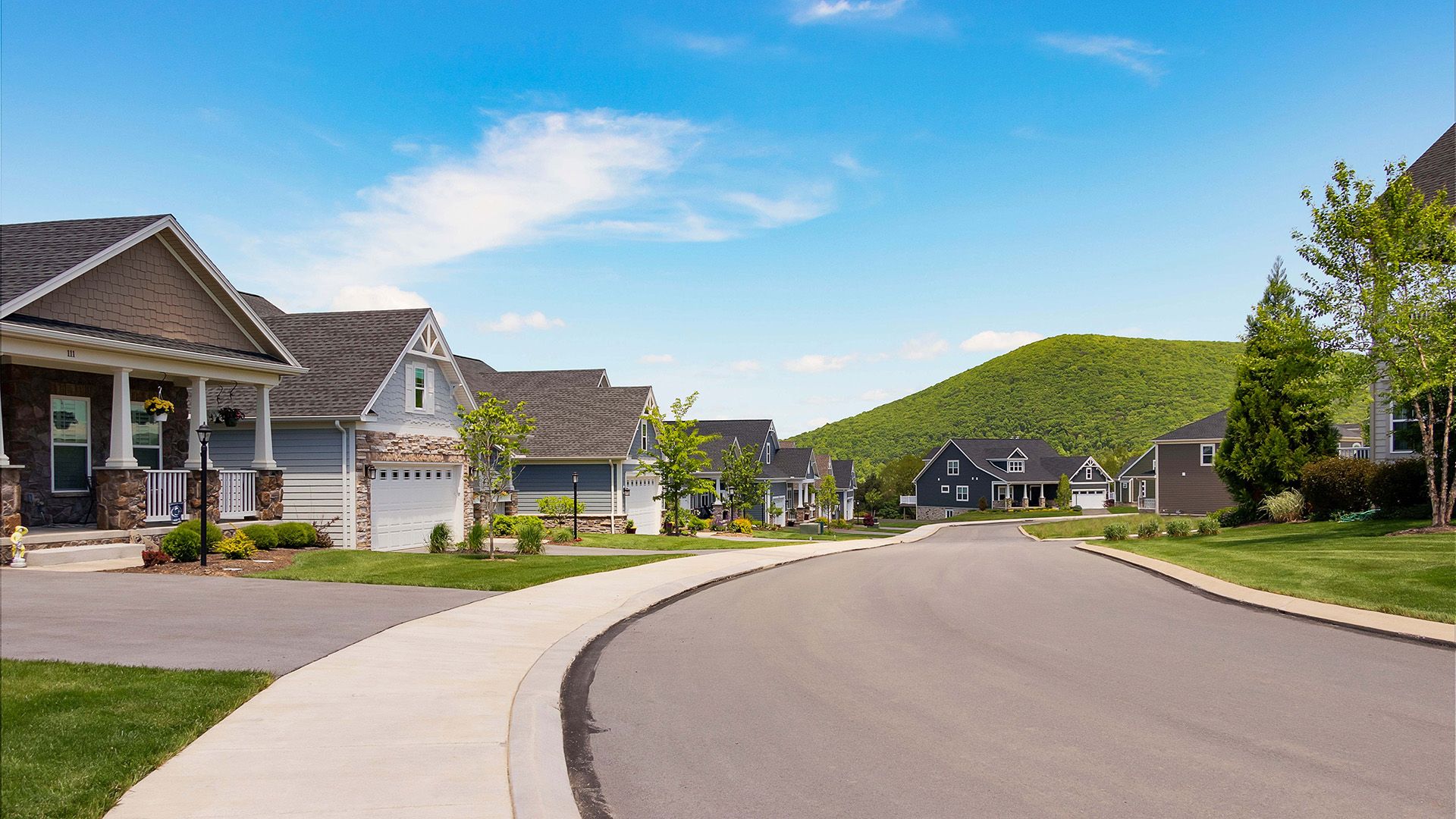 Village at Canterbury in State College - streetscape image of ranch style single family homes with Mt. Nittany in the distance