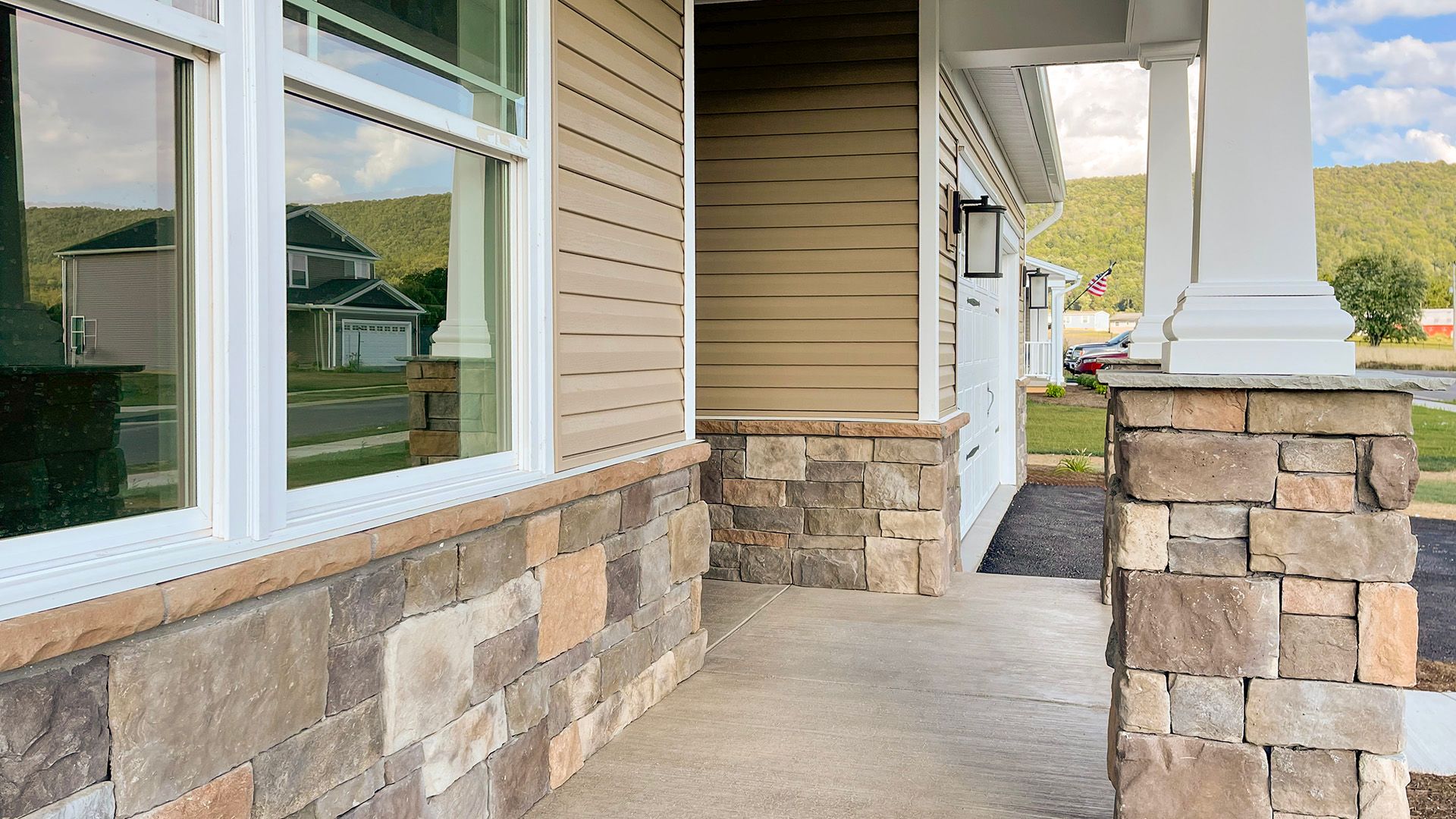 Front porch with partial stone kneewall and stone pillars