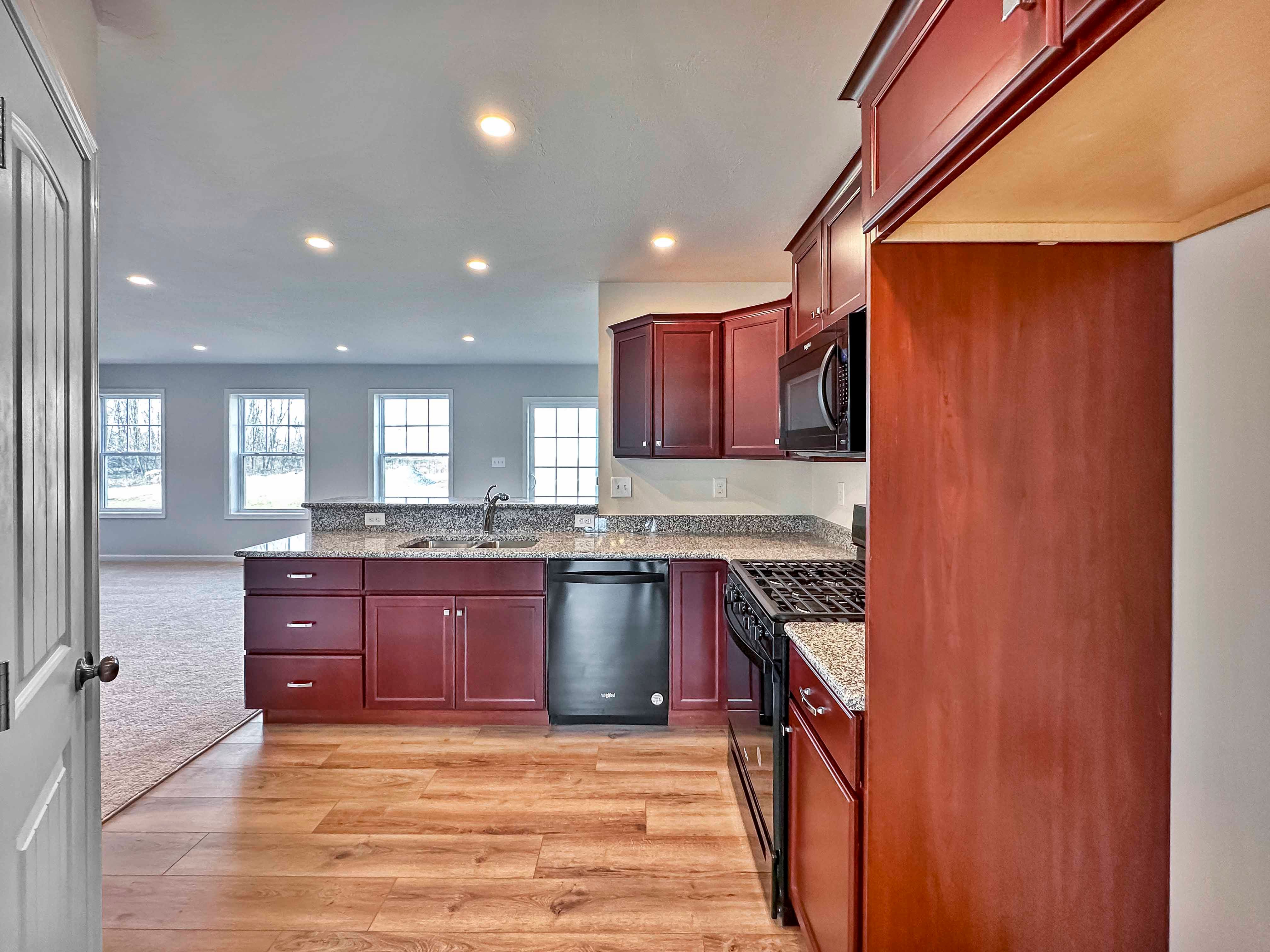 Kitchen with maple cabinets, granite countertops and black appliances