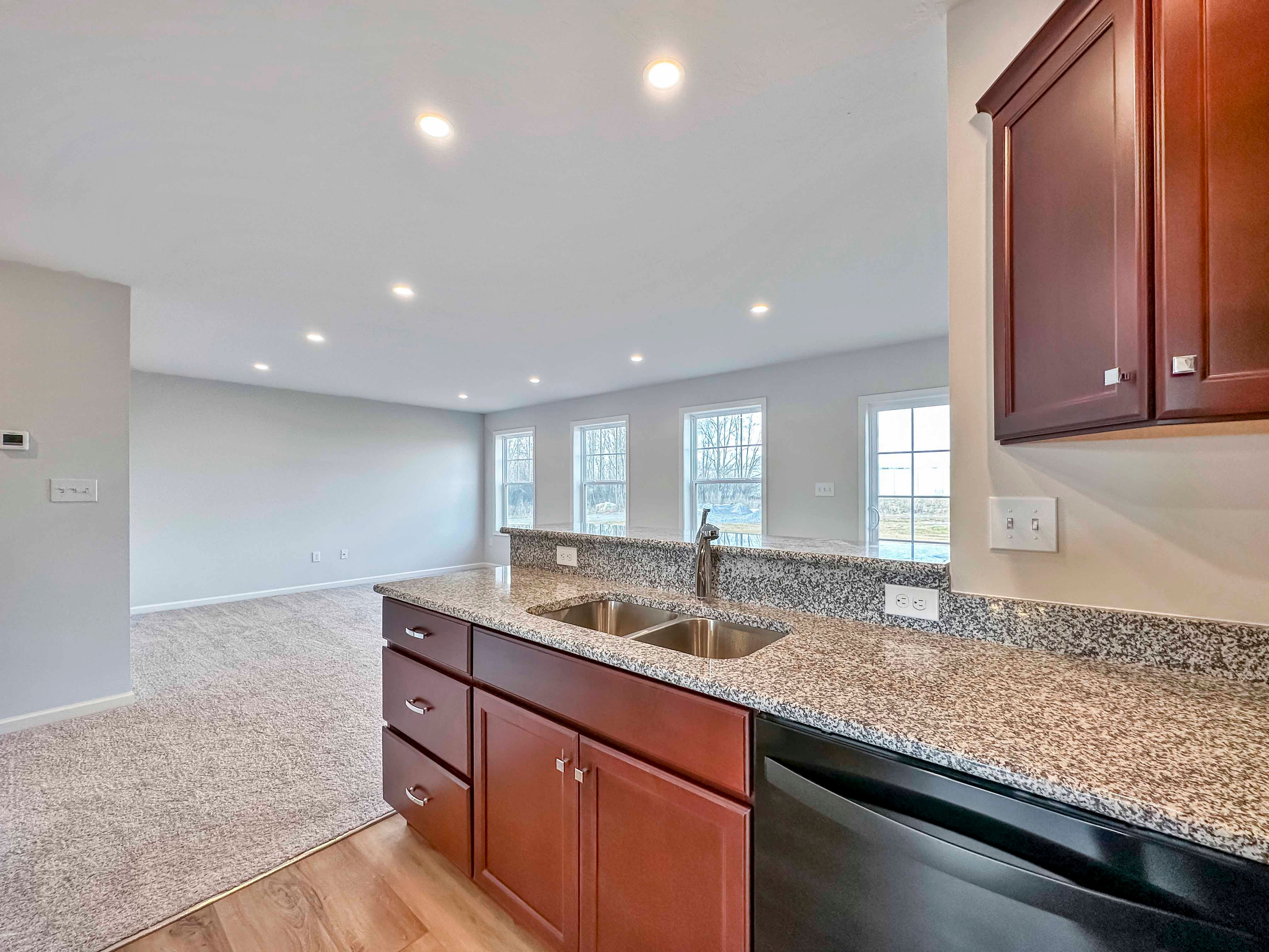 Kitchen with maple cabinets, granite countertops and black appliances