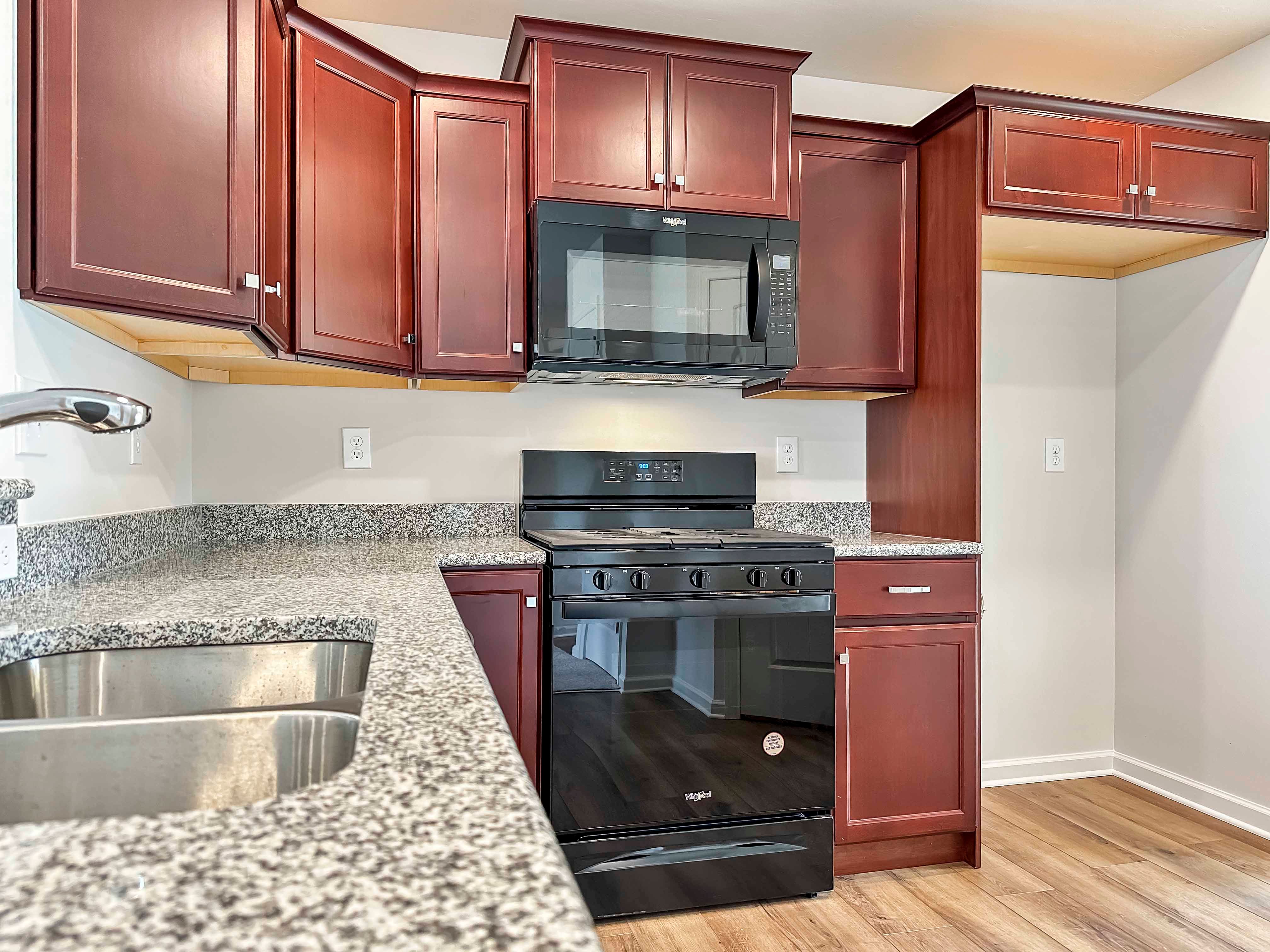 Kitchen with maple cabinets, granite countertops and black appliances