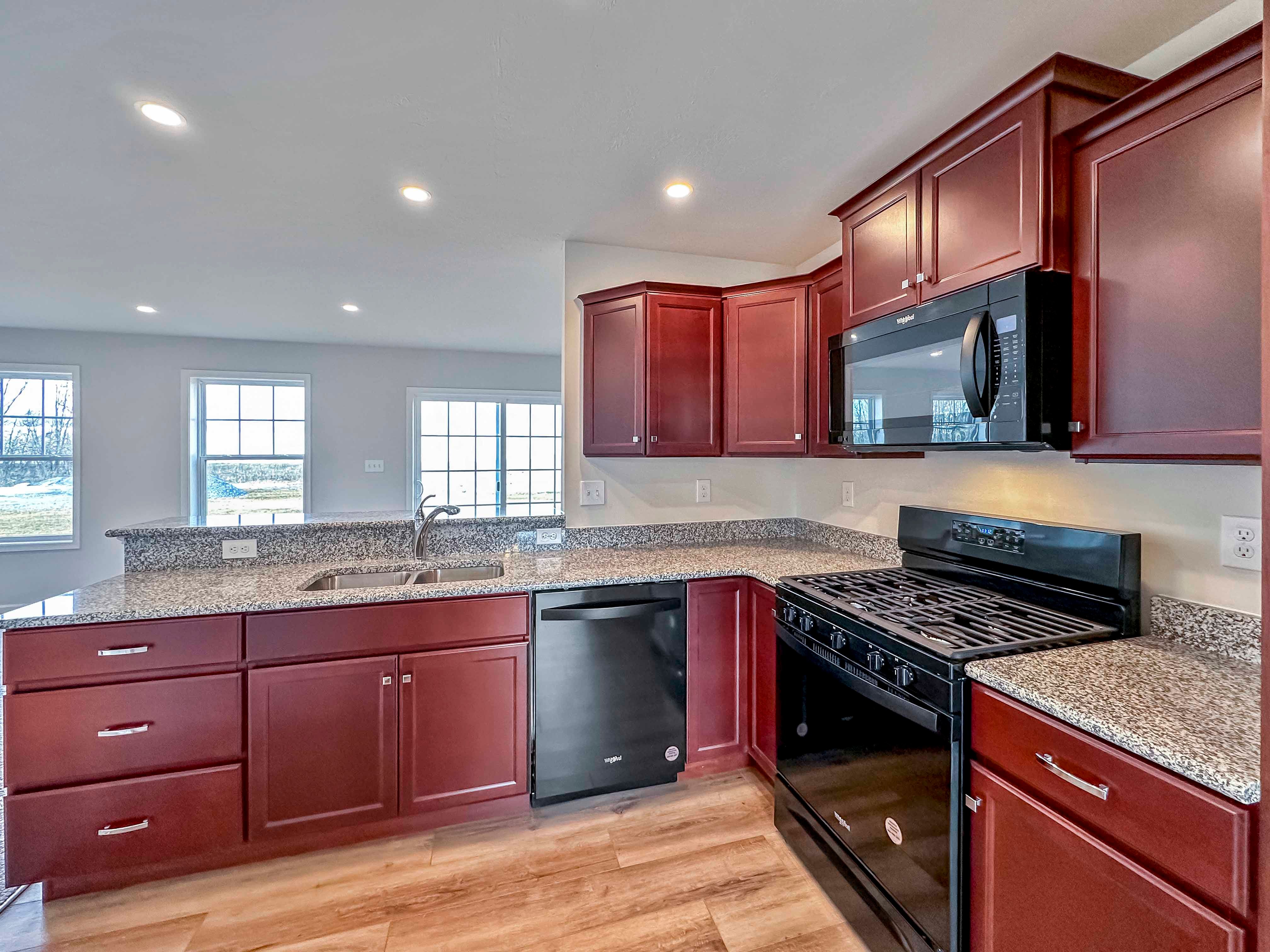 Kitchen with maple cabinets, granite countertops and black appliances
