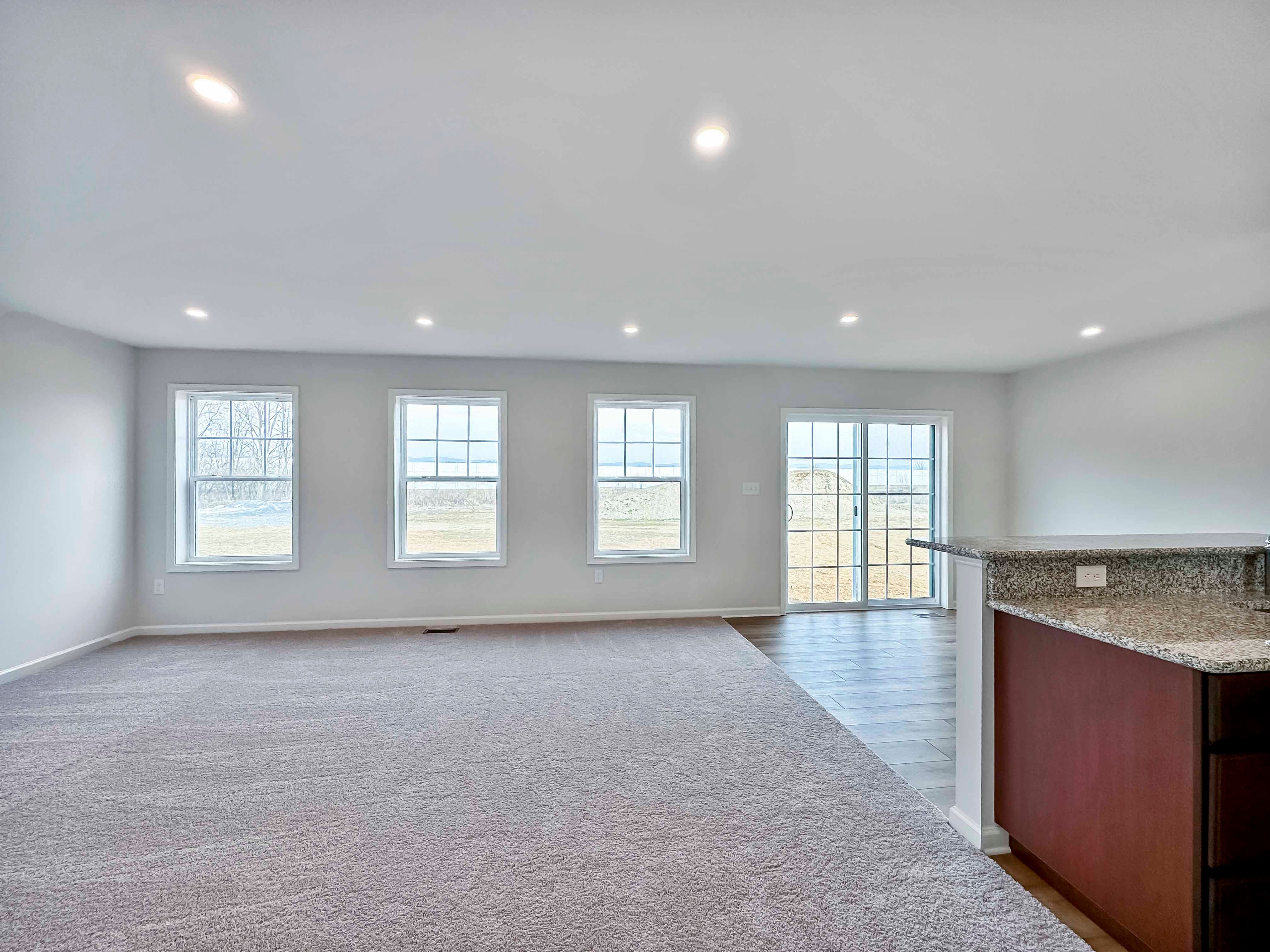 Family Room with 3 windows and sliding door on rear wall