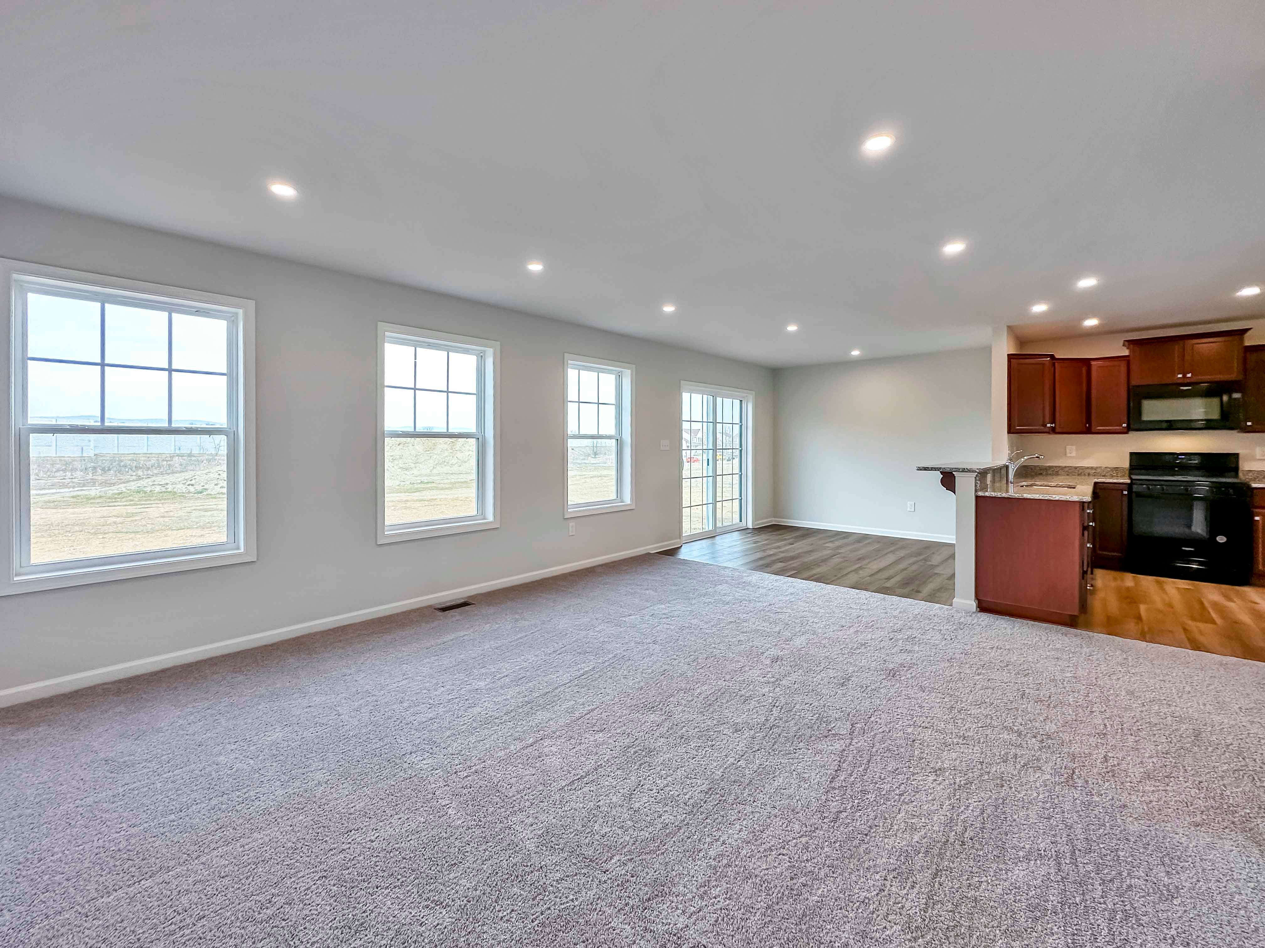 Family Room with 3 windows and sliding door on rear wall