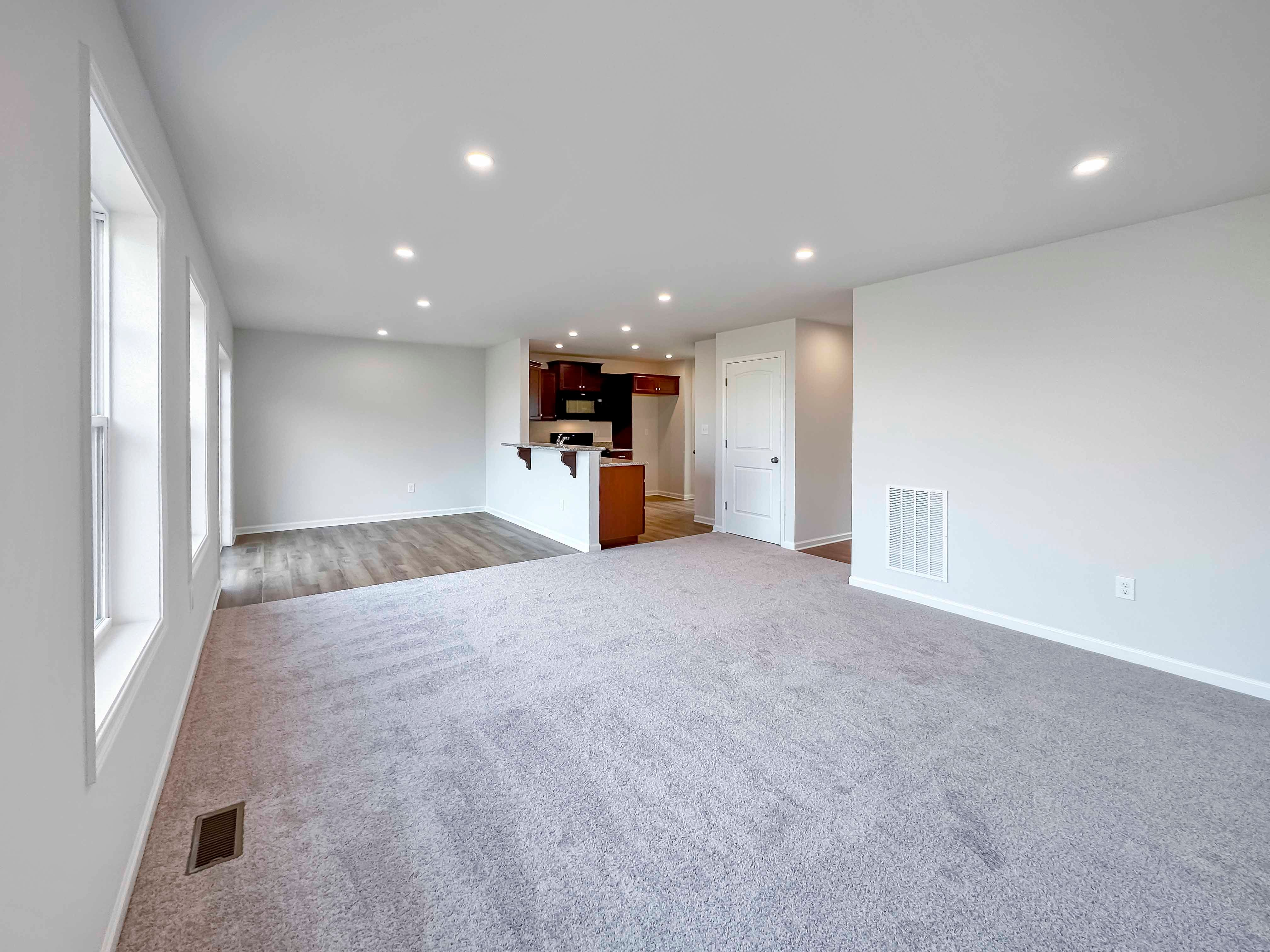 Family Room with 3 windows and sliding door on rear wall