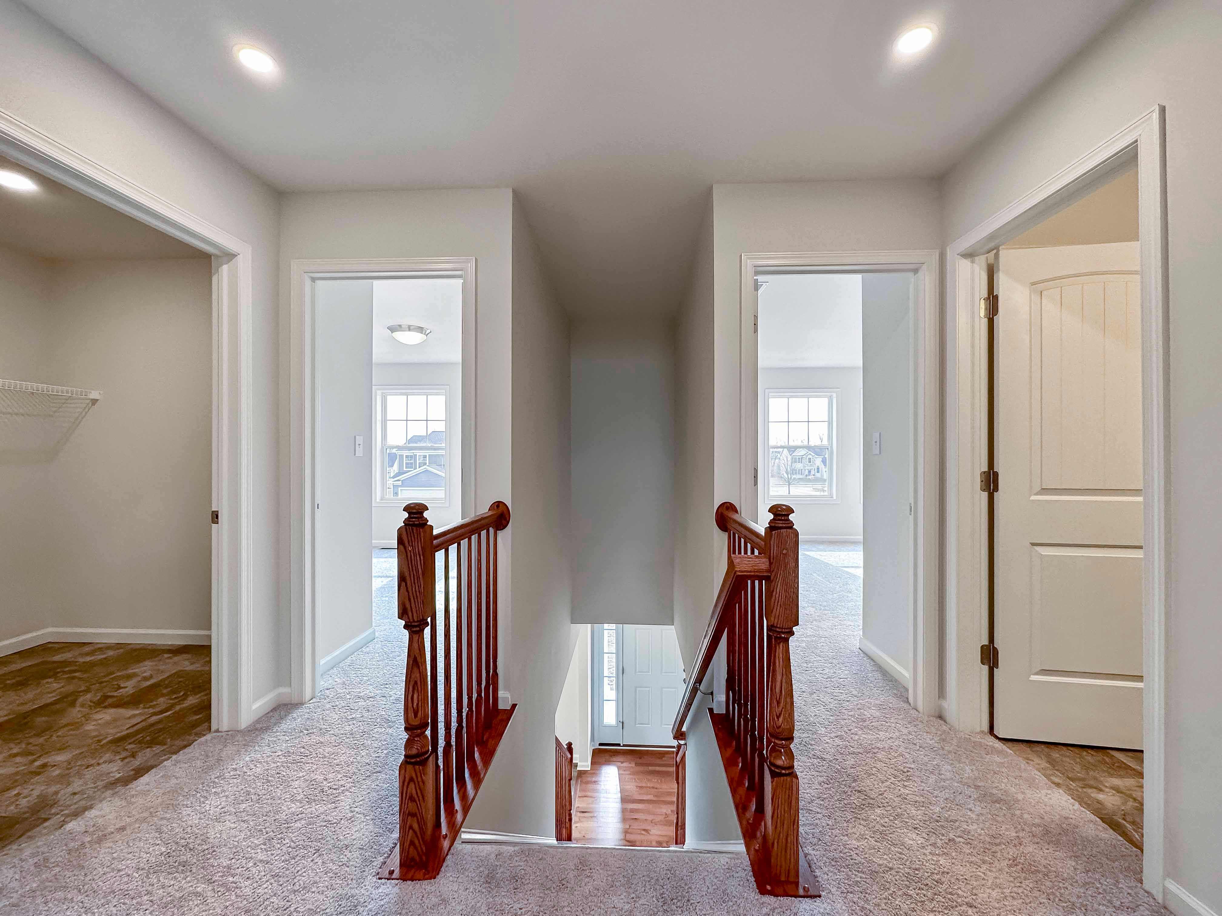 U shaped hallway with stairs leading down to main level