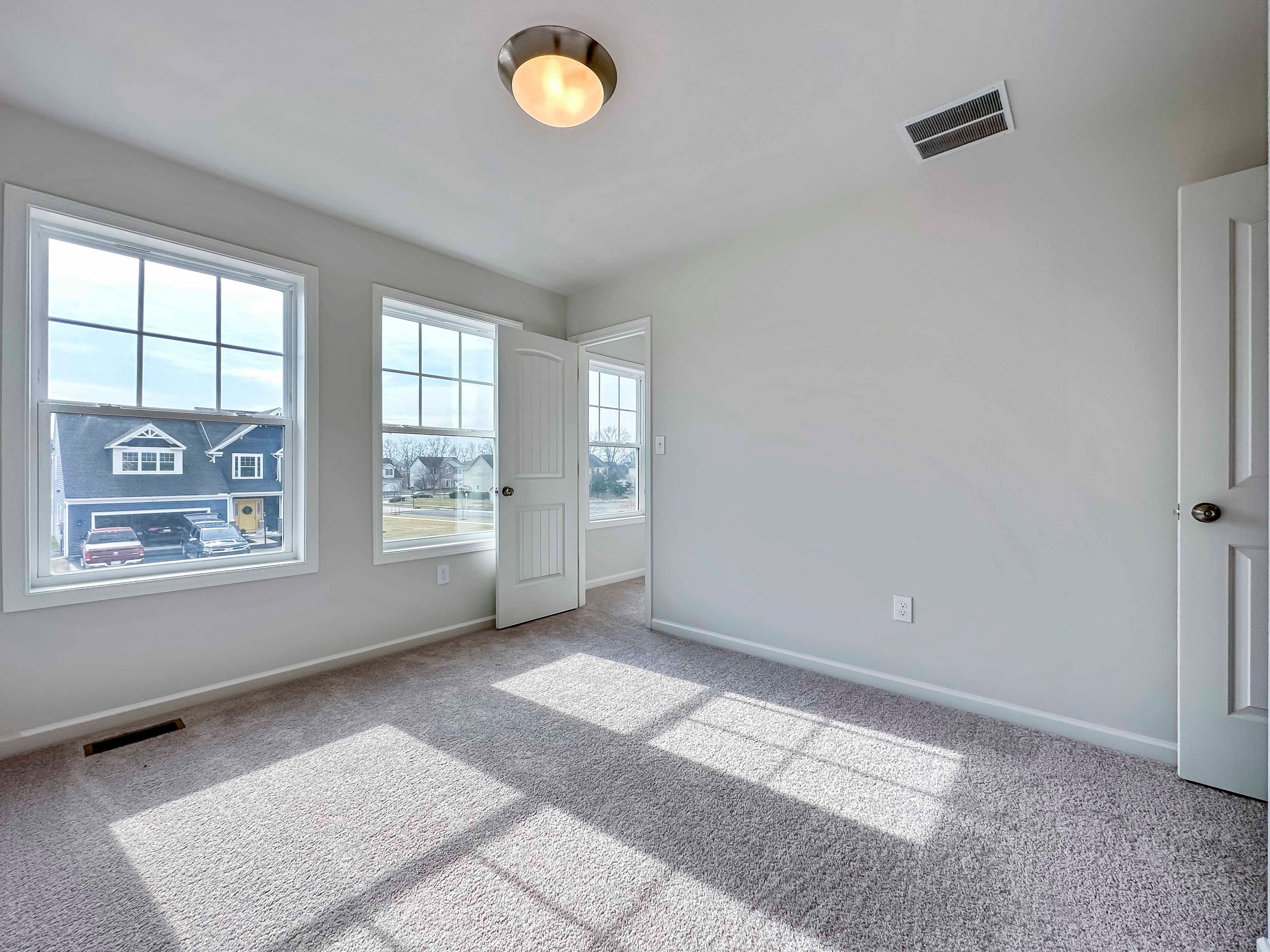 Bedroom with 2 windows on front wall - facing doorway into closet